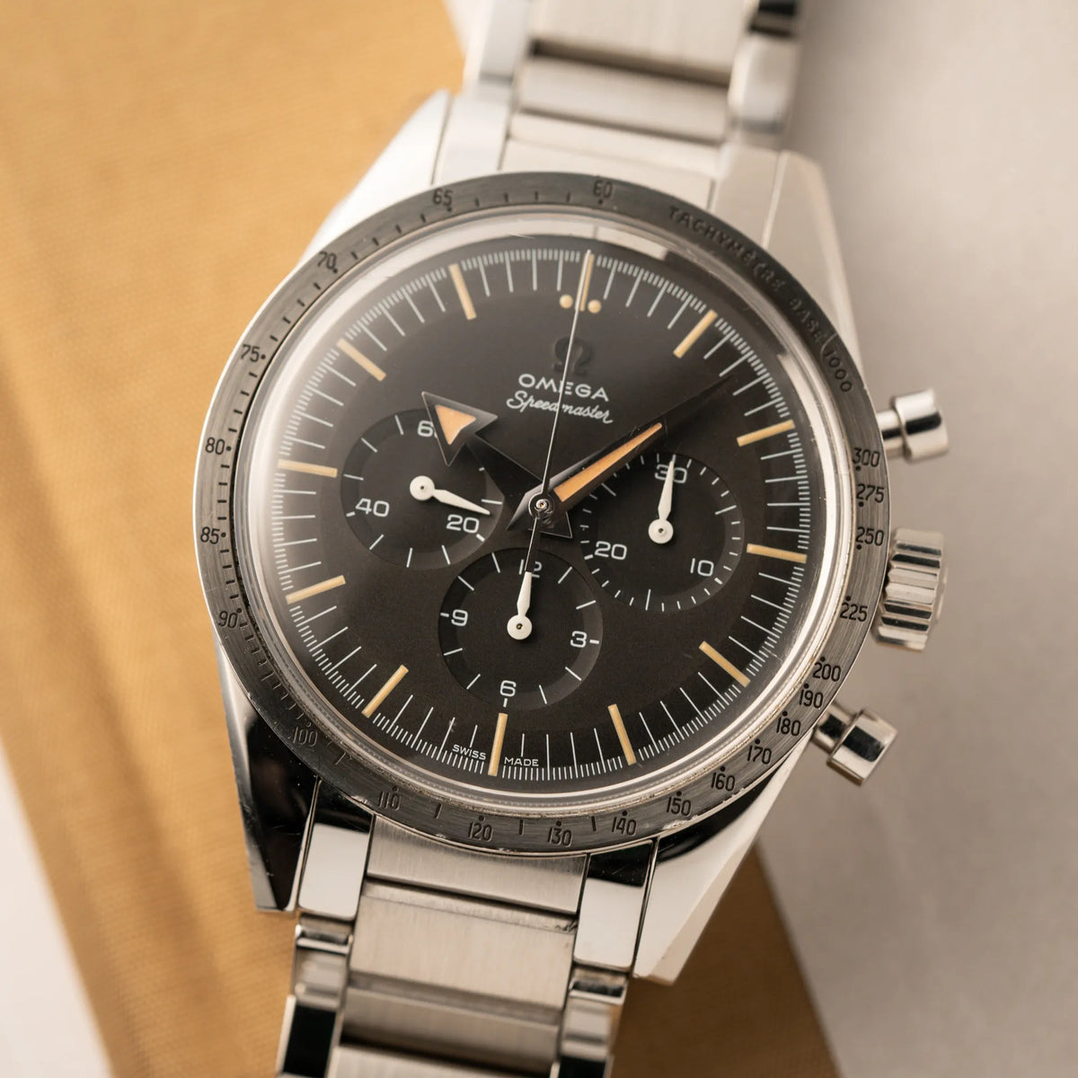 Detailaufnahme der Omega Speedmaster 1957 Trilogy Limited Edition mit einem anthrazitfarbenen Zifferblatt mit Vintage-Look und dem original Omega-Stahlband im Ed-White-Design
