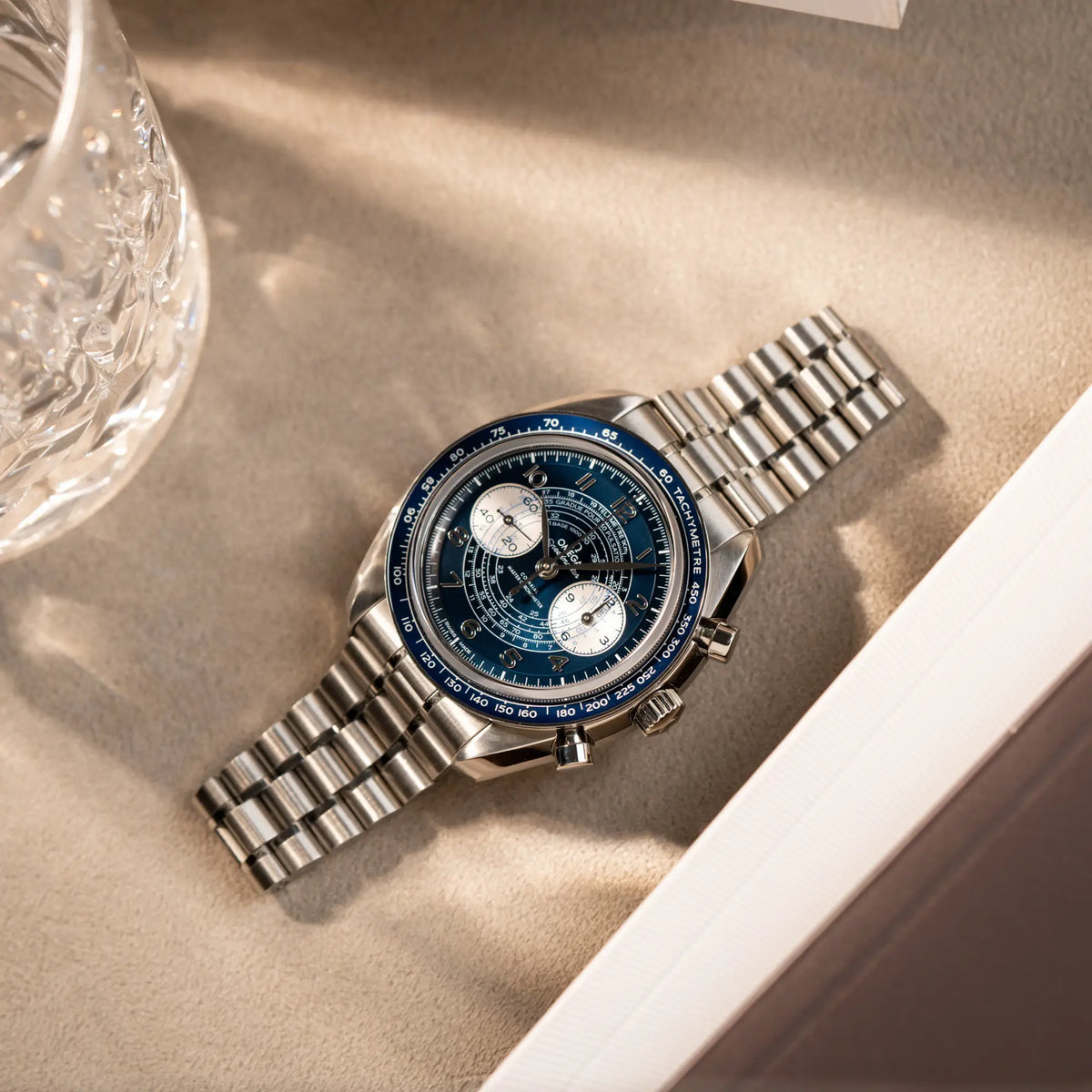 Omega Speedmaster Chronoscope aus Edelstahl mit blauem Zifferblatt und Pulsometerskala, sowie Telemeterskala liegt auf Juwelierstablet