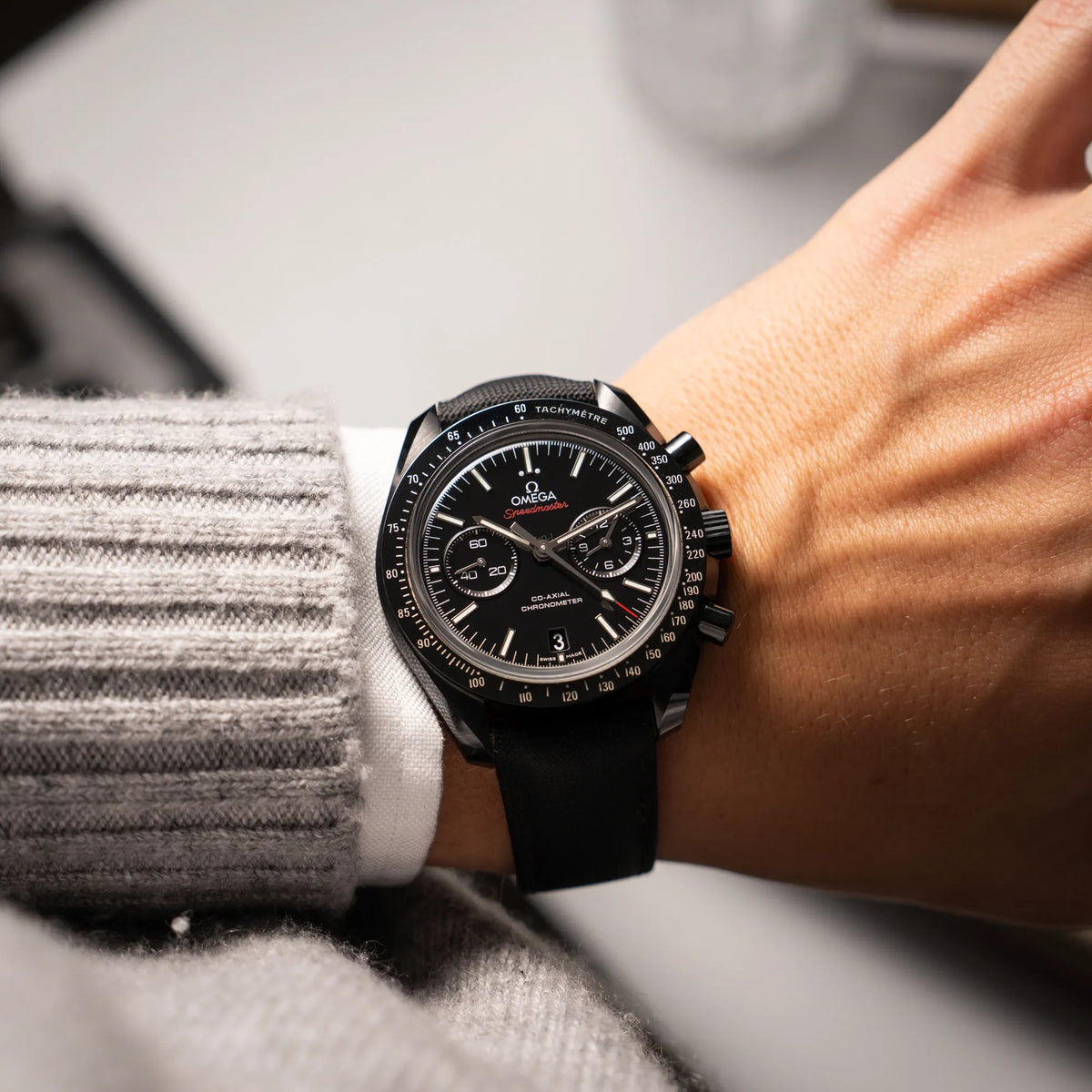 Mann trägt den Omega Speedmaster "Darkside of the Moon" Chronograph mit schwarzem Zifferblatt und aus schwarzer Keramik gefertigtem Gehäuse an seinem Handgelenk