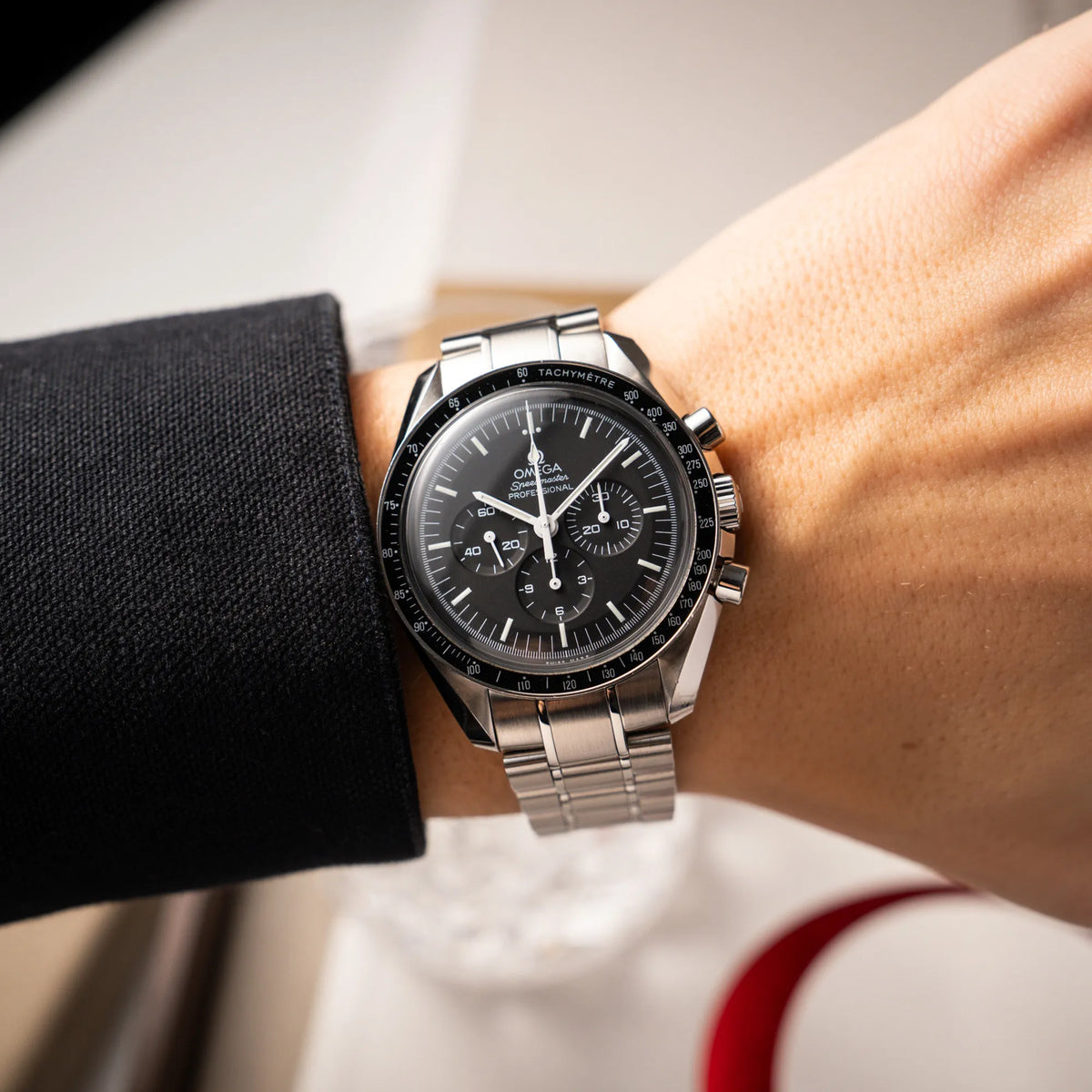 Mann trägt die Omega Speedmaster Professional Moonwatch der Referenz 311.30.42.30.01.005 in einem 42mm-Gehäuse mit klassischem schwarzen Zifferblatt und verbautem Hesalitglas an seinem Handgelenk
