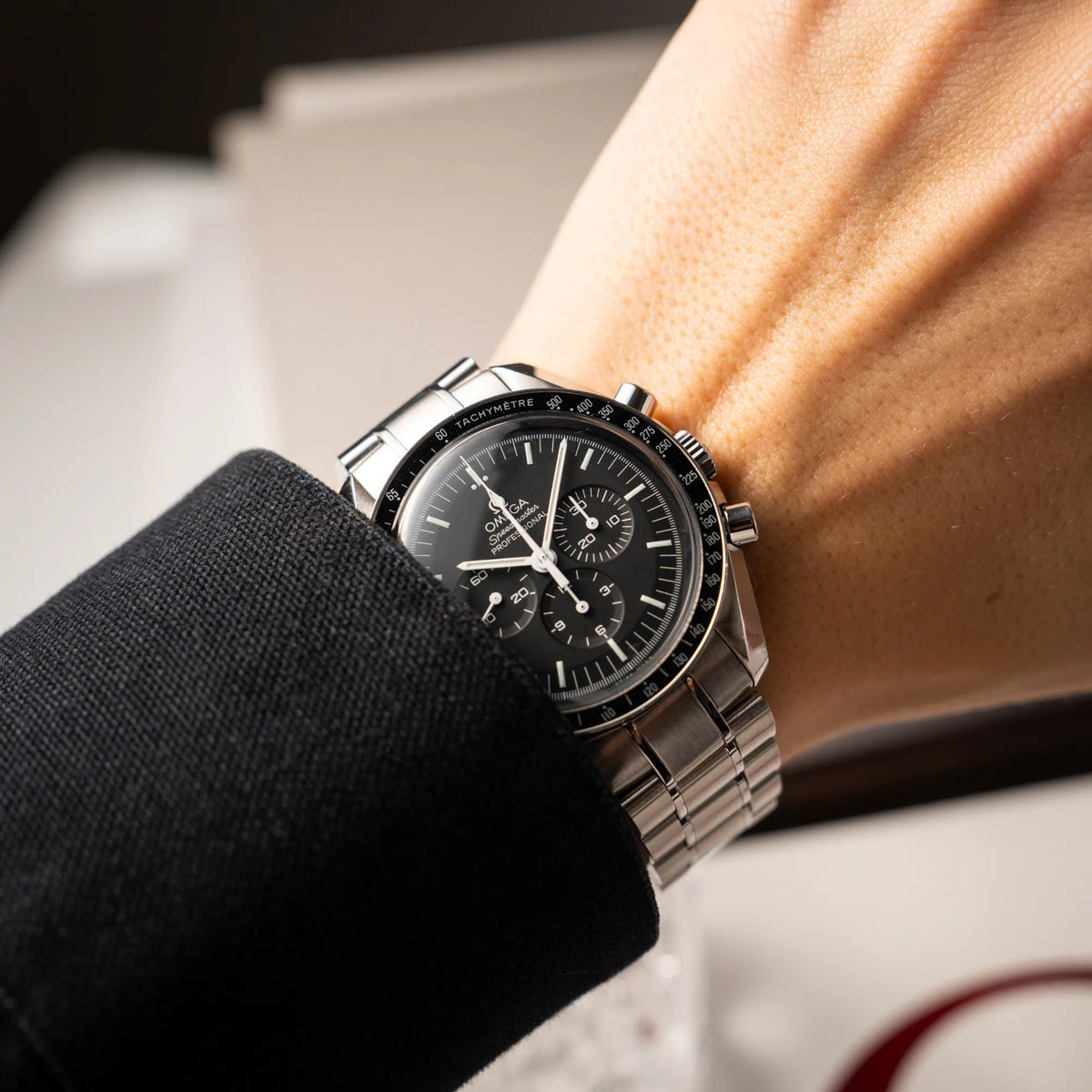 Mann trägt die Omega Speedmaster Professional Moonwatch der Referenz 311.30.42.30.01.005 in einem 42mm-Gehäuse mit klassischem schwarzen Zifferblatt und verbautem Hesalitglas für einen Wristshot an seinem Handgelenk