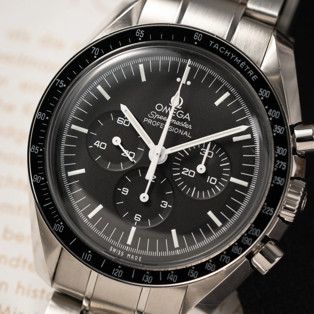 Detailaufnahme des Uhrenkopfes der Omega Speedmaster Professional Moonwatch der Referenz 311.30.42.30.01.005 in einem 42mm-Gehäuse mit klassischem schwarzen Zifferblatt und verbautem Hesalitglas
