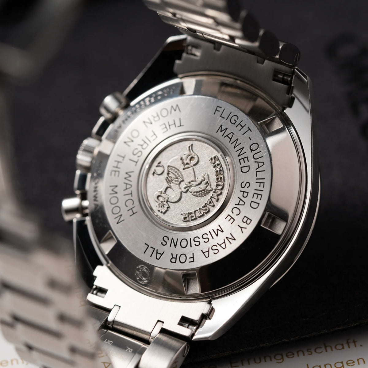 Produktfotografie der Omega Speedmaster Professional Moonwatch der Referenz 311.30.42.30.01.005 in einem 42mm-Gehäuse mit klassischem schwarzen Zifferblatt und verbautem Hesalitglas zeigt den klassischen Speedmaster-Gehäudedeckel aus Edelstahl