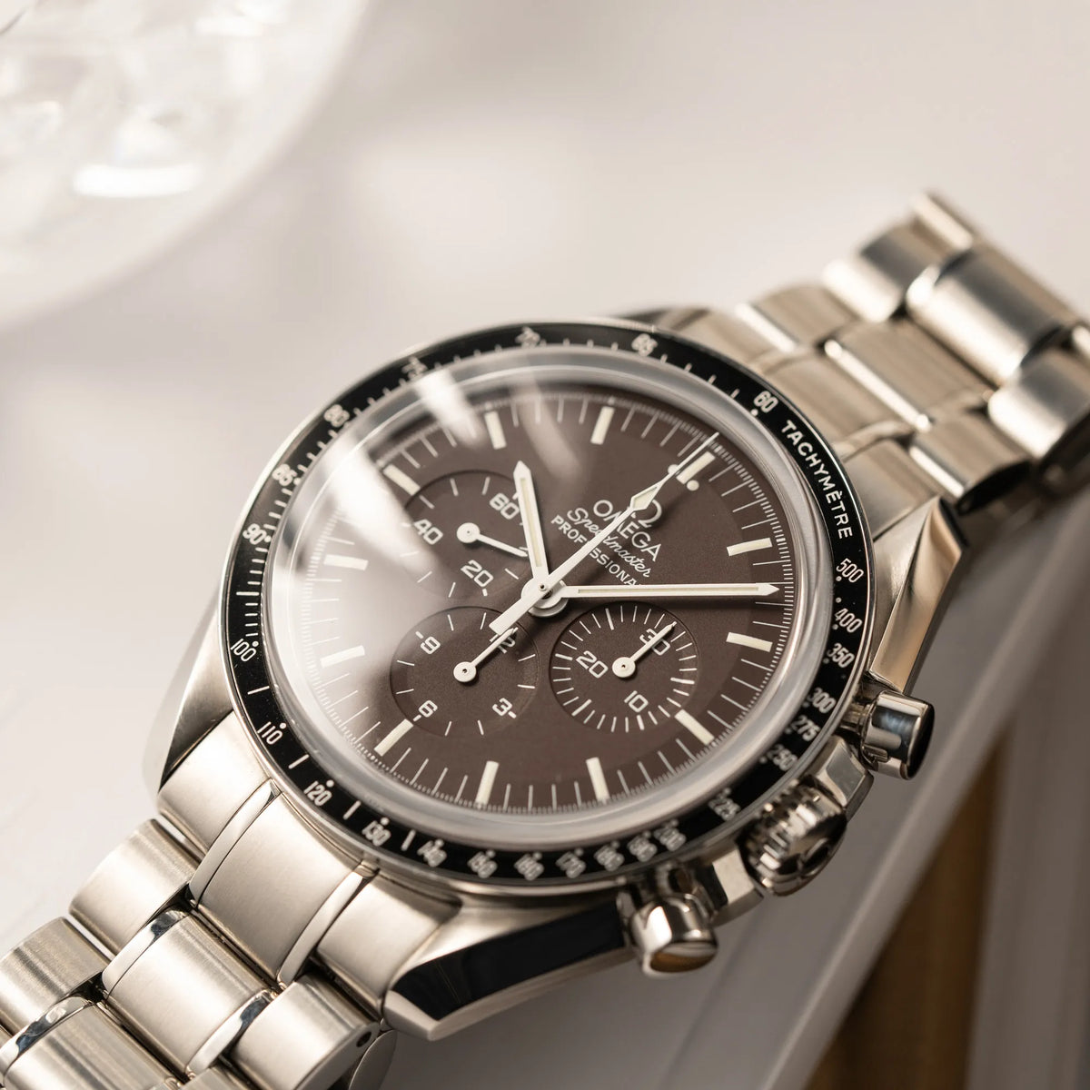 Produktfotografie als Titelbild für die Omega Speedmaster Professional Moonwatch mit einem braunen Zifferblatt