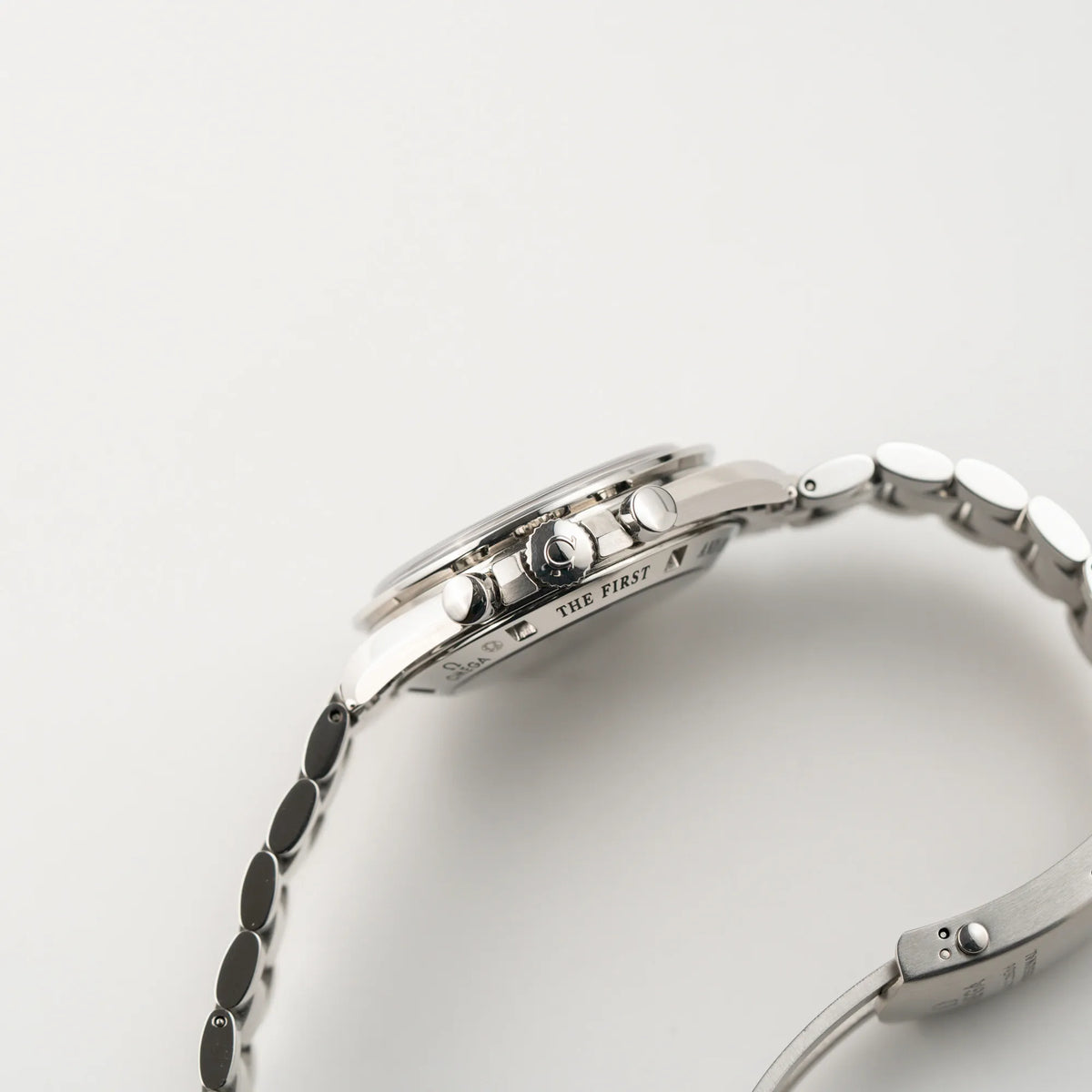 Seitliche Gehäusflanke der Omega Speedmaster Professional Moonwatch mit einem braunen Zifferblatt mit Blick auf die Aufzugskrone und die Chronograph-Drücker