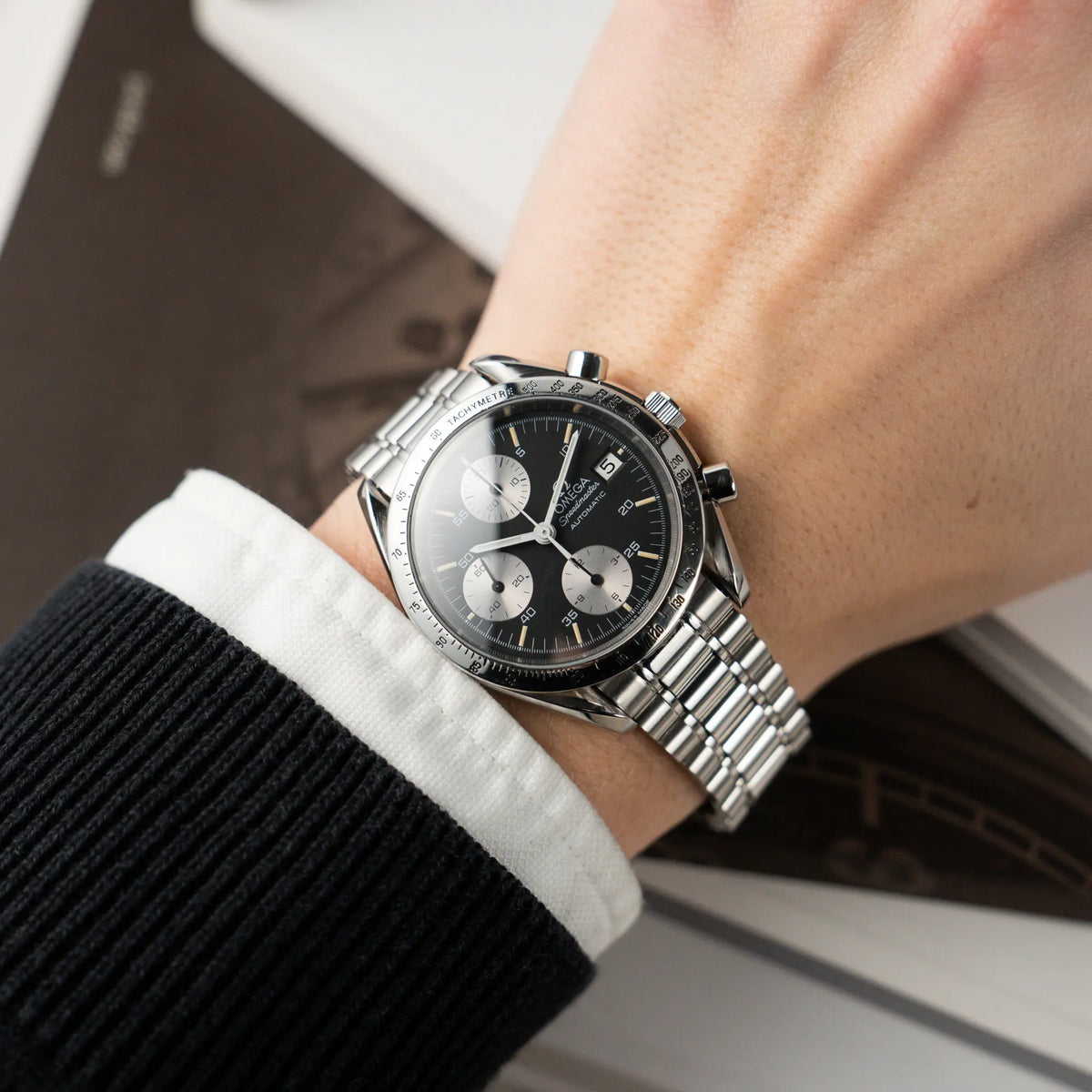 Wristshot mit der Omega Speedmaster Automatic Date mit schwarzem Zifferblatt und silbernen Totalisatoren