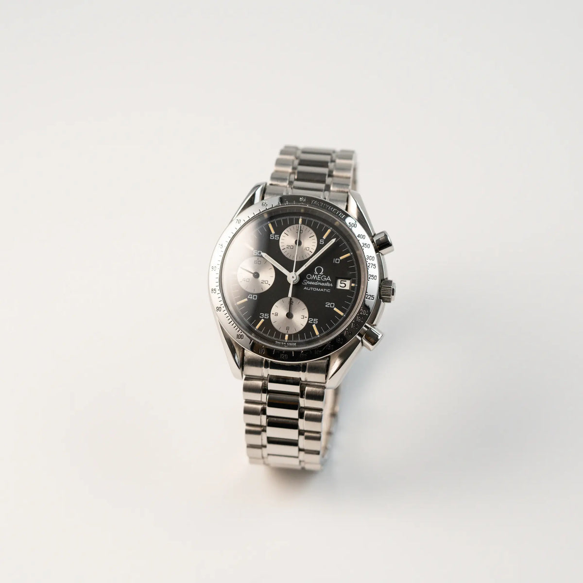 Leicht schräge Ansicht der Omega Speedmaster Automatic Date mit schwarzem Zifferblatt und silbernen Totalisatoren