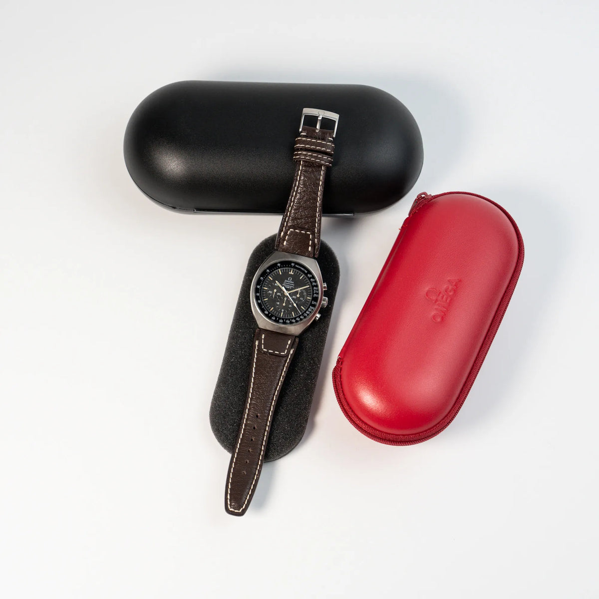 Lieferumfang zu der Omega Speedmaster Moonwatch Mark 2 an einem braunen Lederarmband, bestehend aus einem Omega-Travelcase