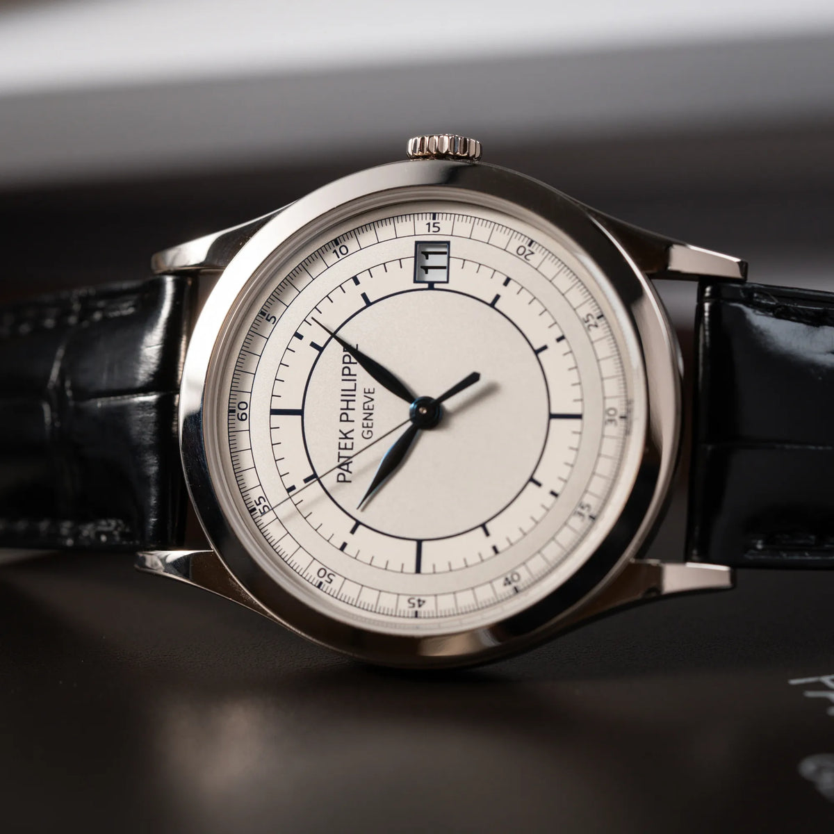 Produktfoto der seitlich auf dem Gehäuse liegenden Patek Philippe Calatrava 5269G in Weißgold mit weißem Sector-Dial 