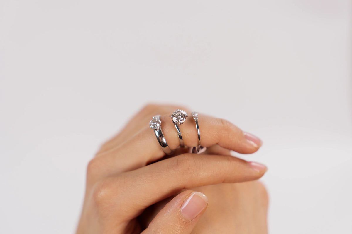 Frau präsentiert 3 Verlobungsringe mit verschieden großen Diamanten aus der Schmuckatelier Lang Collection