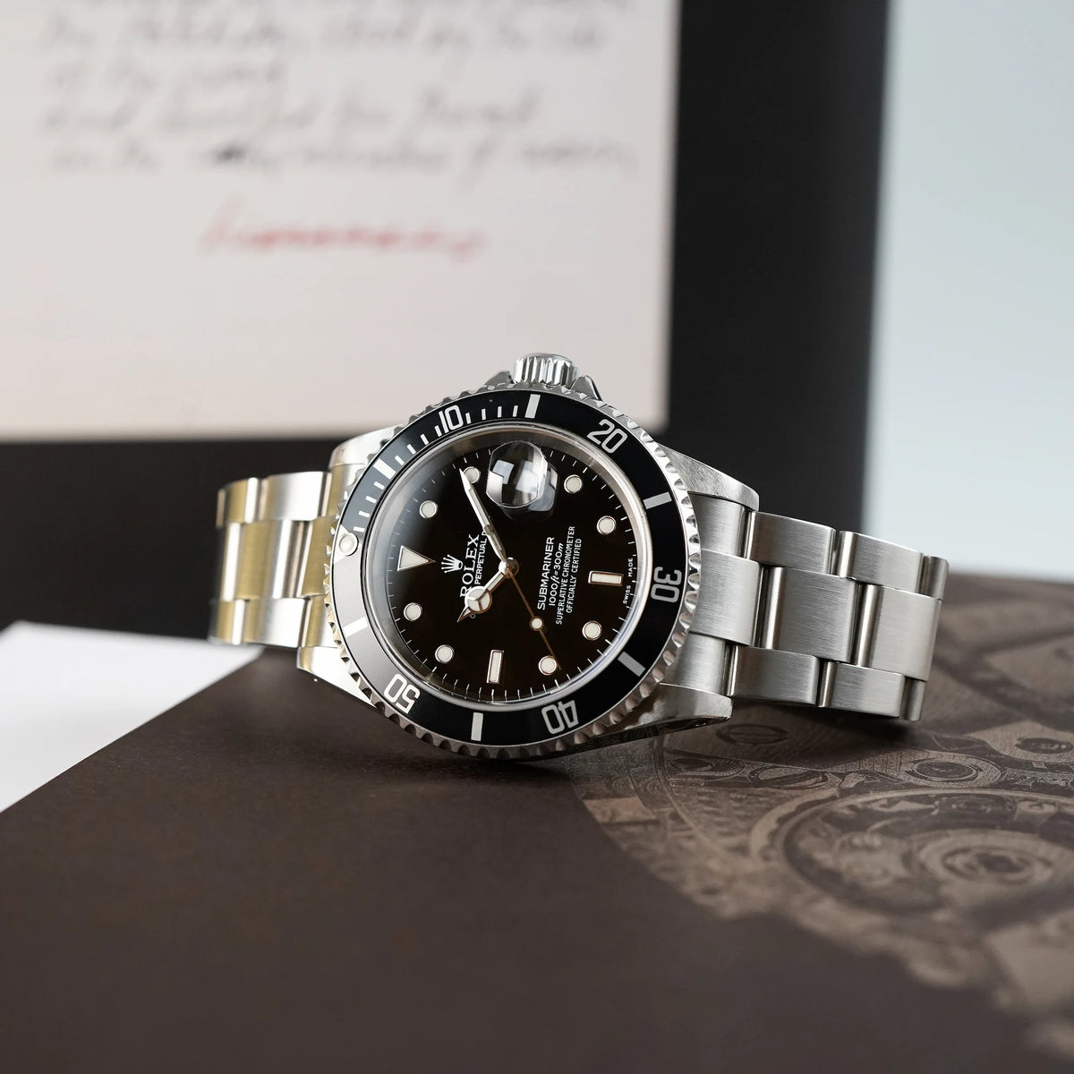 Produktfotografie der liegenden Rolex Submariner Date in schwarz, Referenz 16610, mit Flat-Four-Lünette