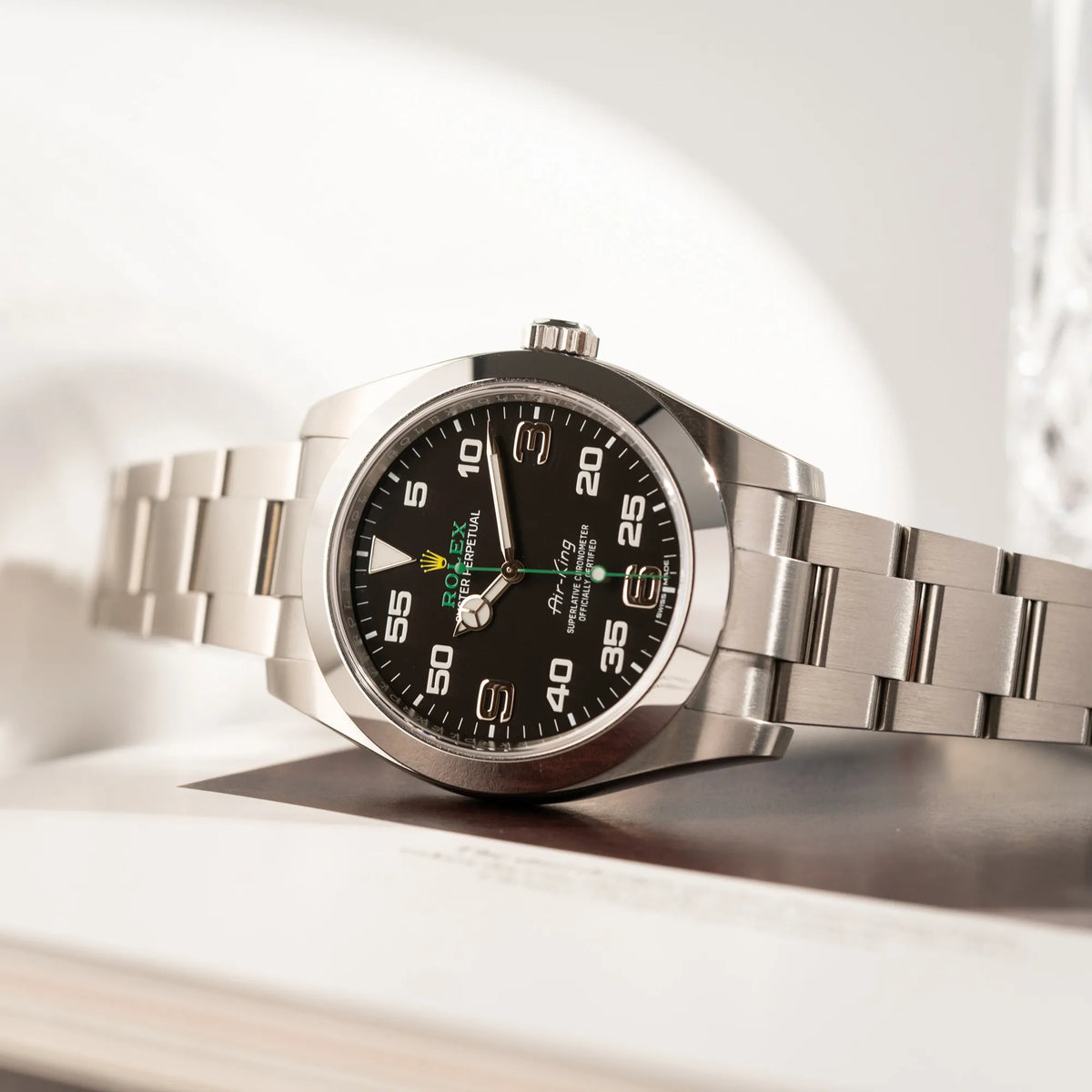 Produktfotografie als Titelbild der Rolex Oyster Perpetual Air King 116900 mit 40mm Gehäuse und dem klassischen schwarzen Zifferblatt mit grünem Sekundenzeiger