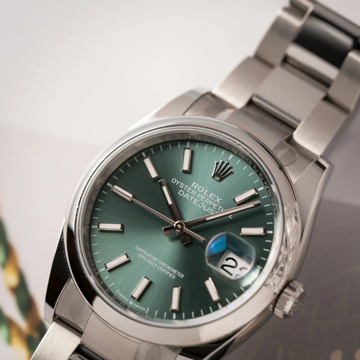 Detailaufnahme des Uhrenkopfes der mit Stickern teil-verklebte Rolex Datejust 36 der Referenz 126200 mit glatter Lünette am Oyster-Stahlband mit dem Mint-Green-Zifferblatt 