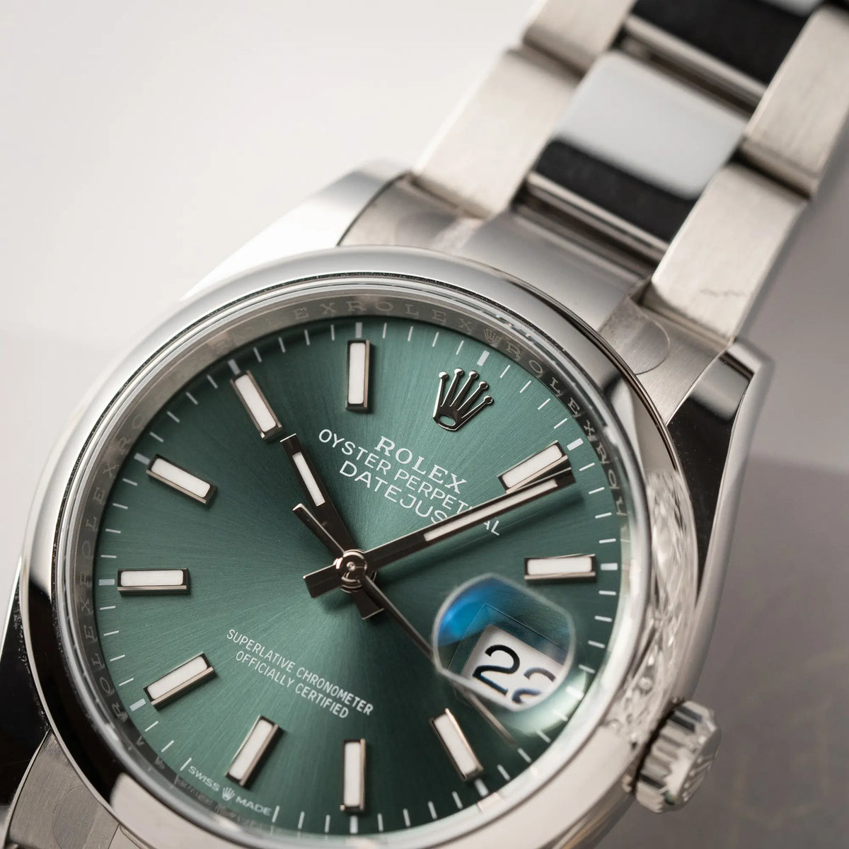 Detailaufnahme der mit Stickern teil-verklebte Rolex Datejust 36 der Referenz 126200 mit glatter Lünette am Oyster-Stahlband mit dem Mint-Green-Zifferblatt 