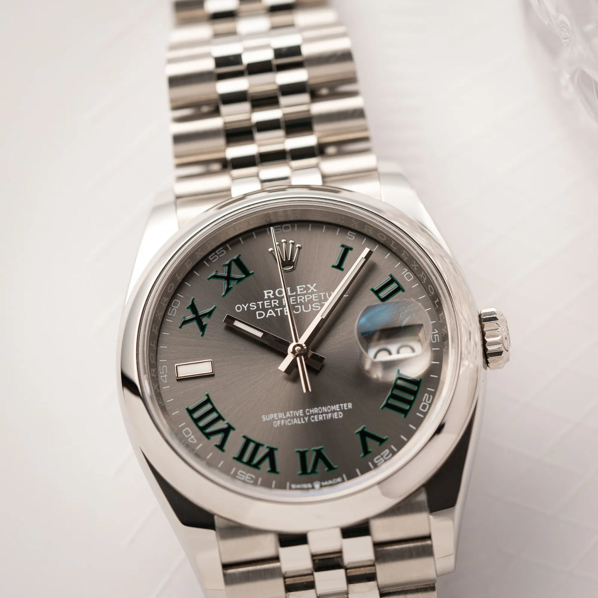 Detailaufnahme der  Rolex Datejust 36 Wimbledon der Referenz  126200 mit glatter Lünette, anthrazitfarbenem Zifferblatt und schwarz-grünen, römischen Indizes am Jubillee-Armband