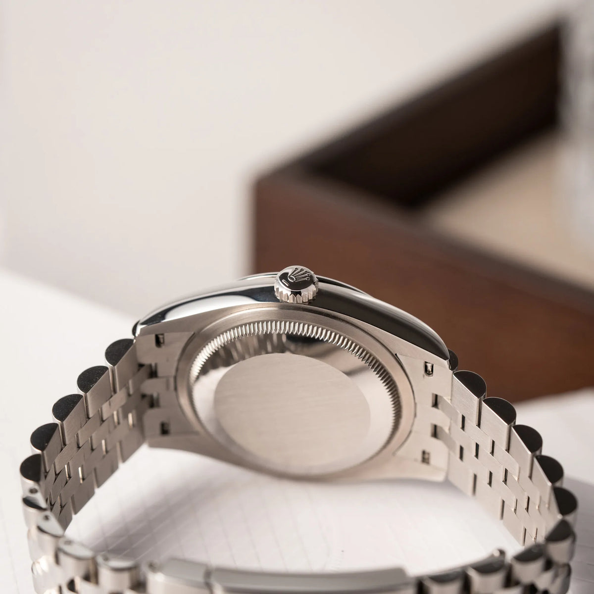 Produktfotografie der Rolex Datejust 36 Wimbledon der Referenz 126200 mit glatter Lünette, anthrazitfarbenem Zifferblatt und schwarz-grünen, römischen Indizes am Jubillee-Armband mit Fokus auf dem Gehäuseboden und der Aufzugskrone