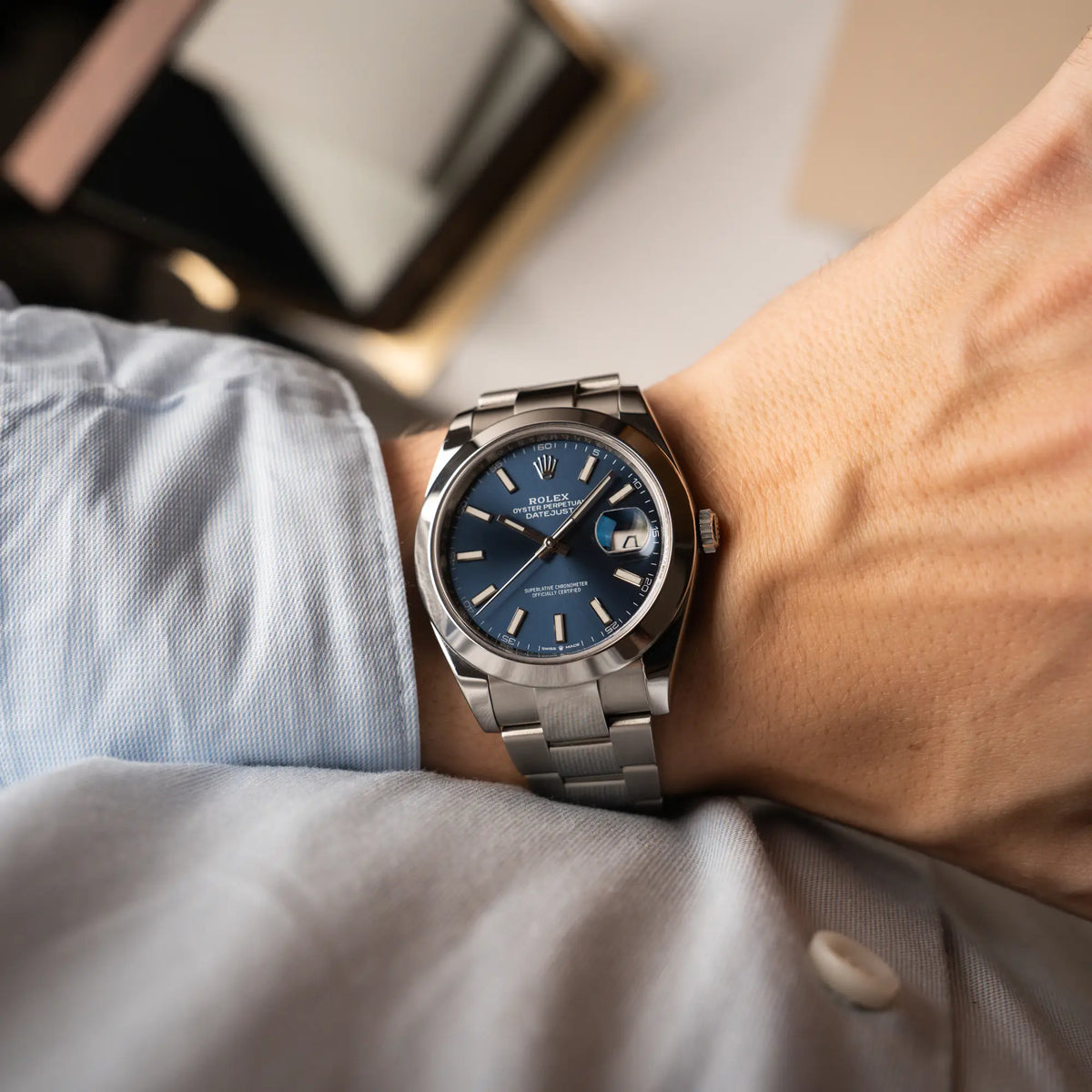 Mann trägt die Rolex Datejust 41 der Referenz 126300 mit blauem Zifferblatt, glatter Lünette, am Oyster-Stahlband für einen Wristshot am Handgelenk