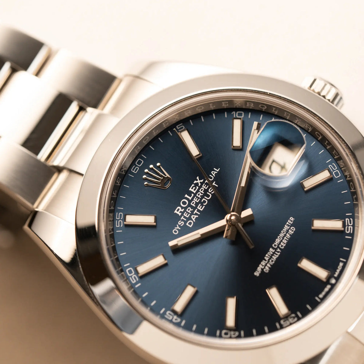 Detailaufnahme der Rolex Datejust 41 der Referenz 126300 mit blauem Zifferblatt, glatter Lünette, am Oyster-Stahlband zeigt die Rolex-Krone auf dem Zifferblatt im Detail