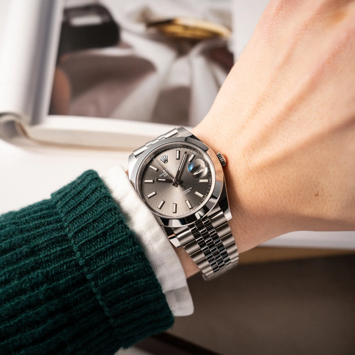 Mann trägt die Rolex Datejust 41 der Referenz 126300 mit grauem Zifferblatt und glatter Lünette am Jubilee-Stahl-Armband an seinem Handgelenk