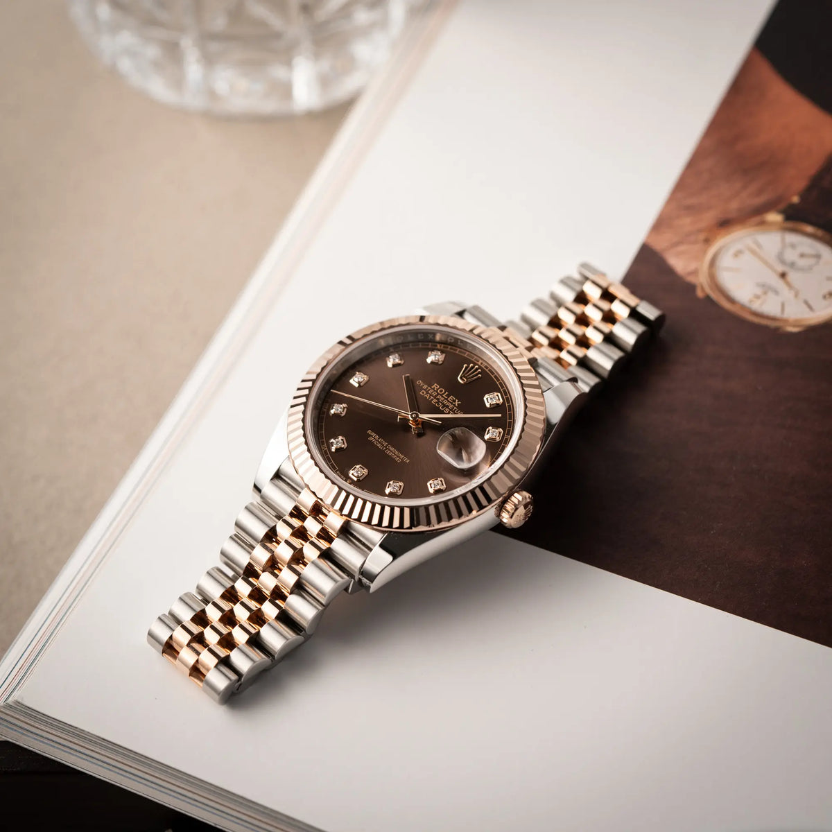 Rolex Datejust 41 126331 in Stahl-Roségold mit dem braunen Chocolate-Diamant-Zifferblatt liegt flach auf einem Uhrenmagazin
