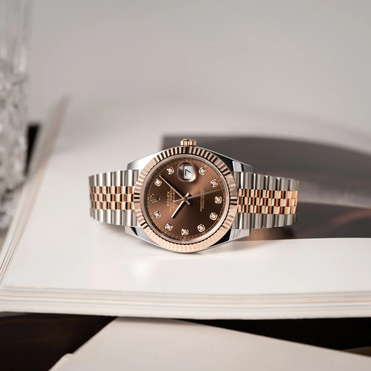 Produktfotografie der seitlich auf der Gehäuseflanke liegenden Rolex Datejust 41 126331 in Stahl-Roségold mit dem braunen Chocolate-Diamant-Zifferblatt