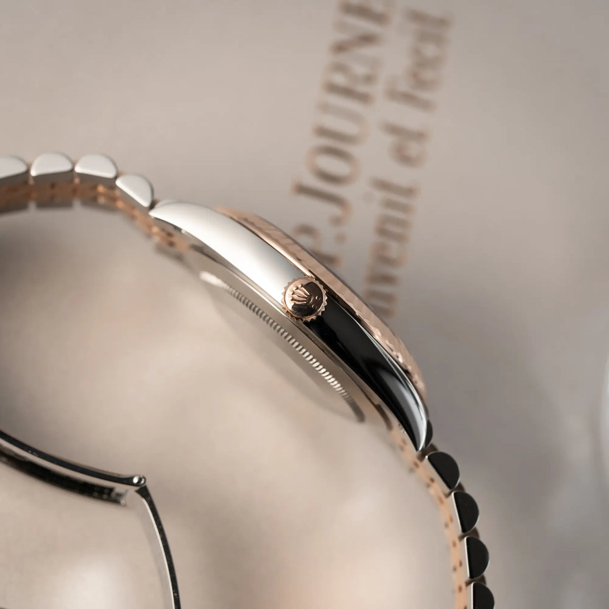 Produktfotografie mit Fokus auf der rosgoldenen Aufzugskrone von der bicolor Rolex Datejust 41 der Referenz 126331 Chocolate in Stahl-Roségold mit einem zum Roségold passenden braunen Zifferblatt am zugehörigen Jubilee-Armband