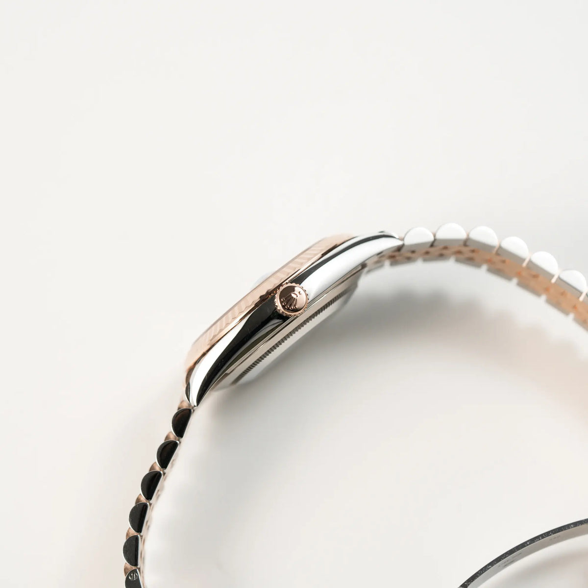 Seitliche Gehäuseflanke der bicolor Rolex Datejust 41 der Referenz 126331 Chocolate in Stahl-Roségold mit einem zum Roségold passenden braunen Zifferblatt am zugehörigen Jubilee-Armband zeigt die roségoldene Aufzugskrone