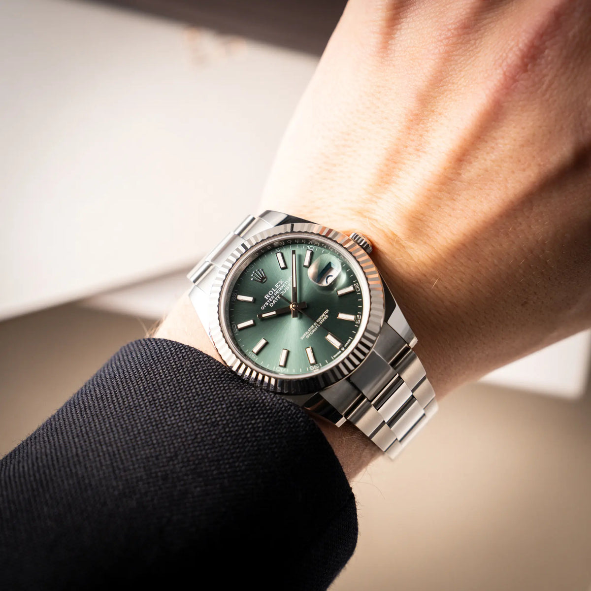 Mann trägt den Wristshot mit der Rolex Datejust 41 der Referenz 126334 mit dem grünem Zifferblatt am Oyster-Stahlband