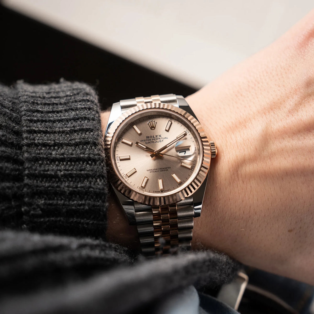Mann trägt die Rolex Datejust 41 in Stahl-Roségold mit am passenden Jubilee-Armband mit dem pink-lachsfarbenen "Sundust" Zifferblatt an seinem Handgelenk