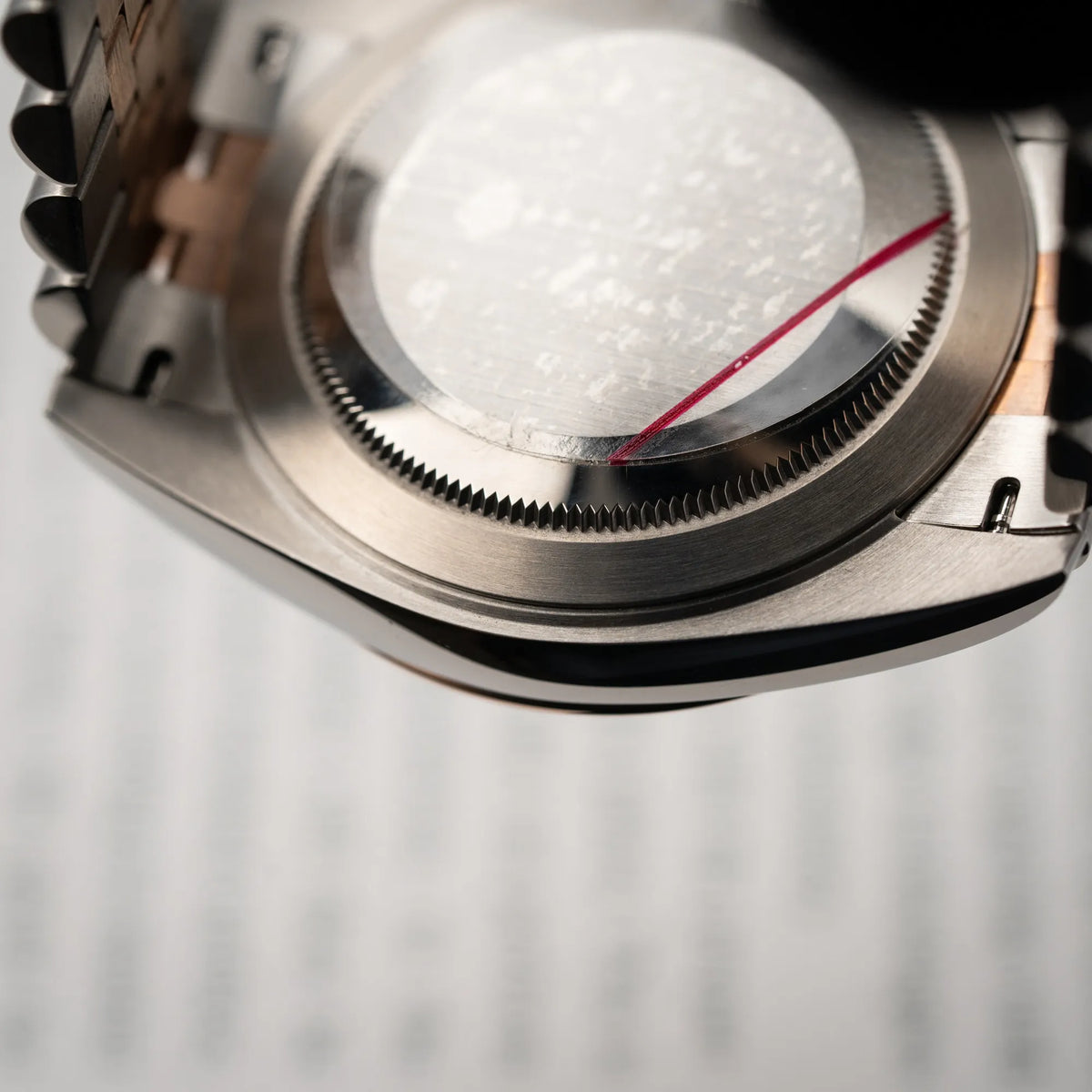 Gehäuseboden mit dem Auslieferungssticker der Rolex Datejust 41 in Stahl-Roségold mit am passenden Jubilee-Armband mit dem pink-lachsfarbenen "Sundust" Zifferblatt
