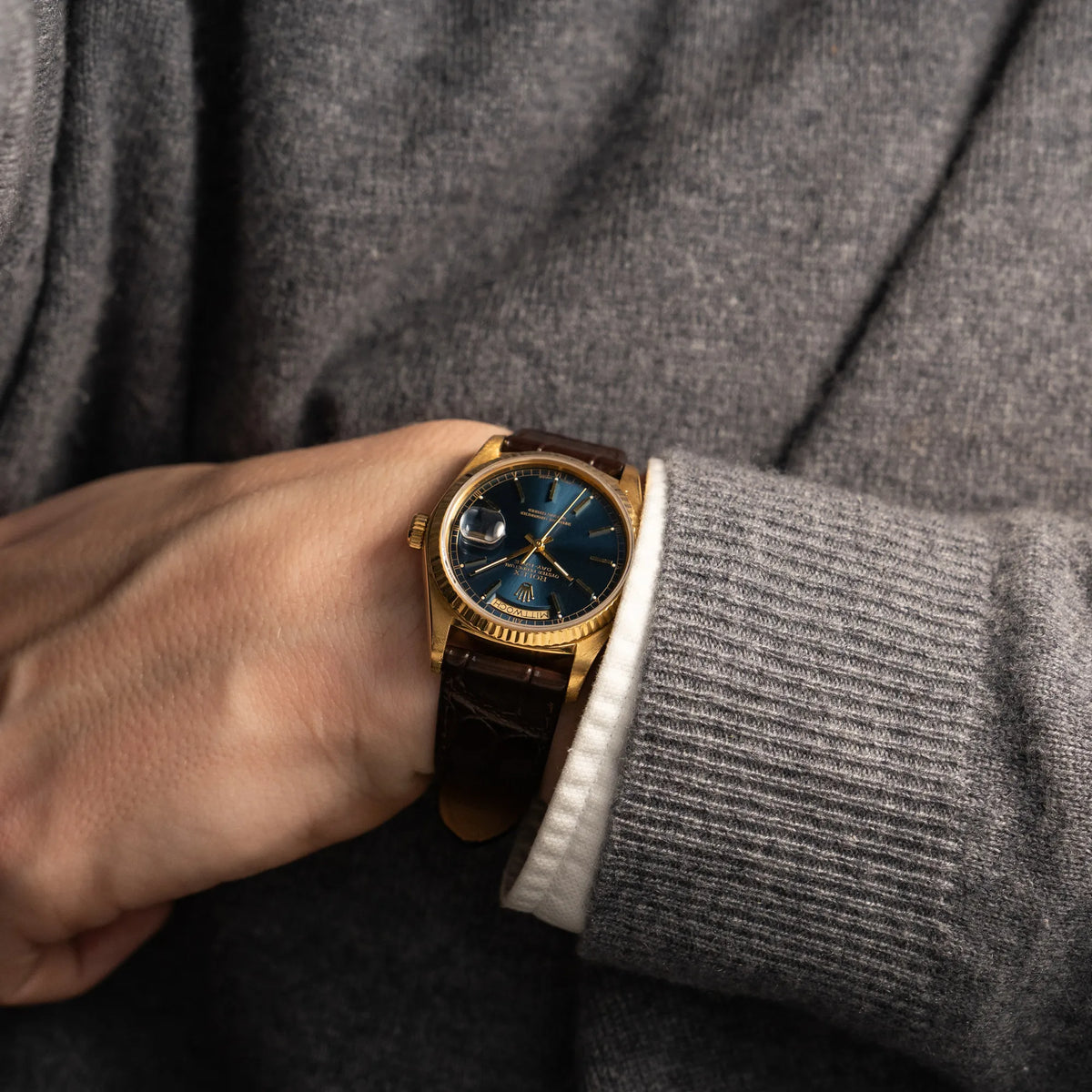 Mann trägt die Rolex Day-Date 36 der Referenz 18038 in Gelbgold mit blauem Zifferblatt am braunen Lederband an seinem Arm