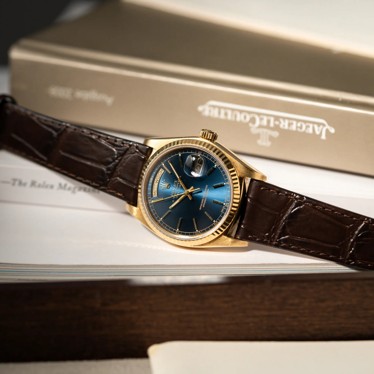 Produktfotografie der Rolex Day-Date 36 der Referenz 18038 in Gelbgold mit blauem Zifferblatt am braunen Lederband