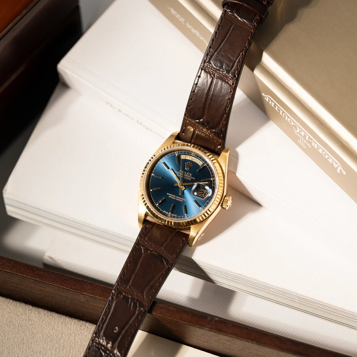 Produktfotografie der Rolex Day-Date 36 der Referenz 18038 in Gelbgold mit blauem Zifferblatt am braunen Lederband