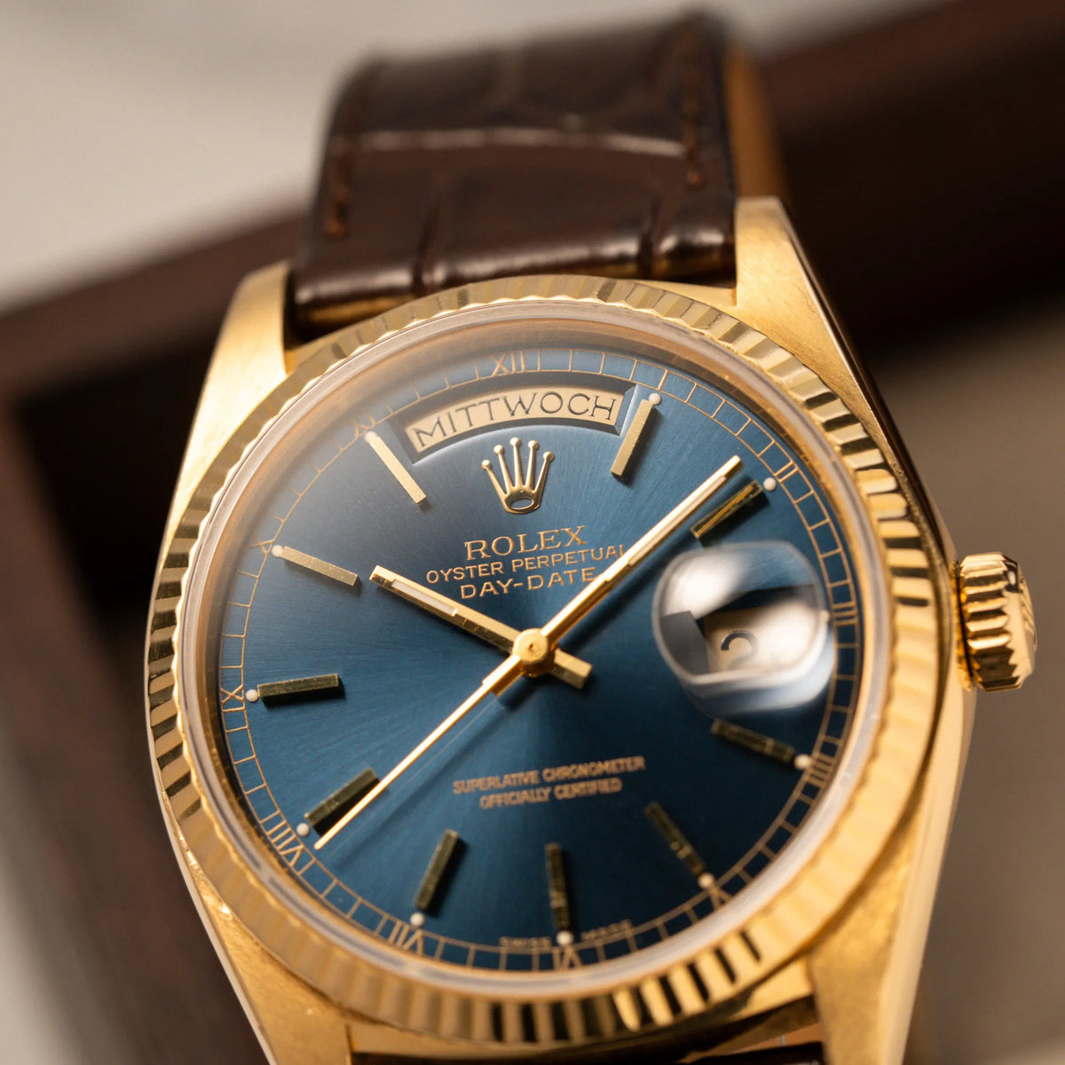 Detailaufnahme der Rolex Day-Date 36 der Referenz 18038 in Gelbgold mit blauem Zifferblatt am braunen Lederband