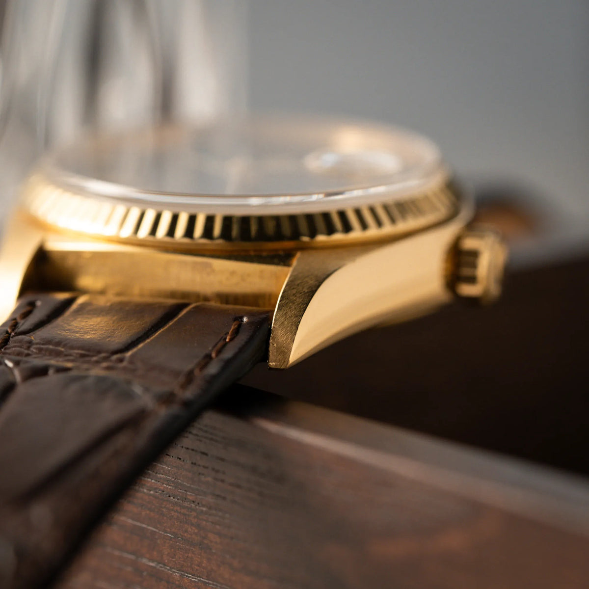 Detailaufnahme des Bandanstoßes der Rolex Day-Date 36 der Referenz 18038 in Gelbgold mit blauem Zifferblatt am braunen Lederband