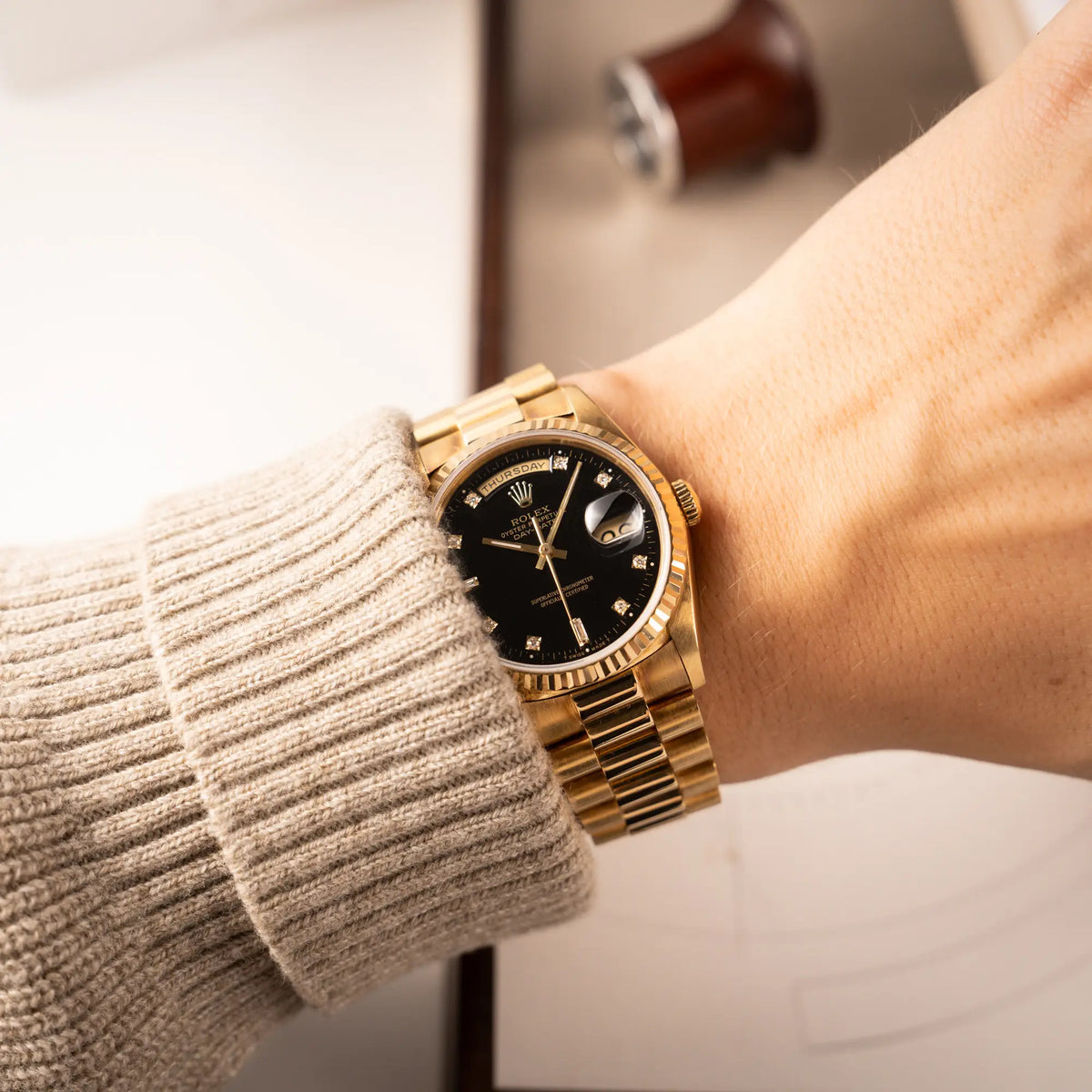 Wristshot mit der Rolex Day-Date 36 in Gelbgold mit der Referenznummer 18238 mit englisches Tagesanzeige, mit schwarzem Lack-Zifferblatt und Diamant-Indizes 