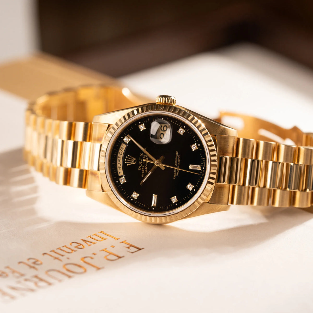Titelbild zu der Rolex Day-Date 36 in Gelbgold mit der Referenznummer 18238 mit englischer Tagesanzeige, mit schwarzem Lack-Zifferblatt und Diamant-Indizes 