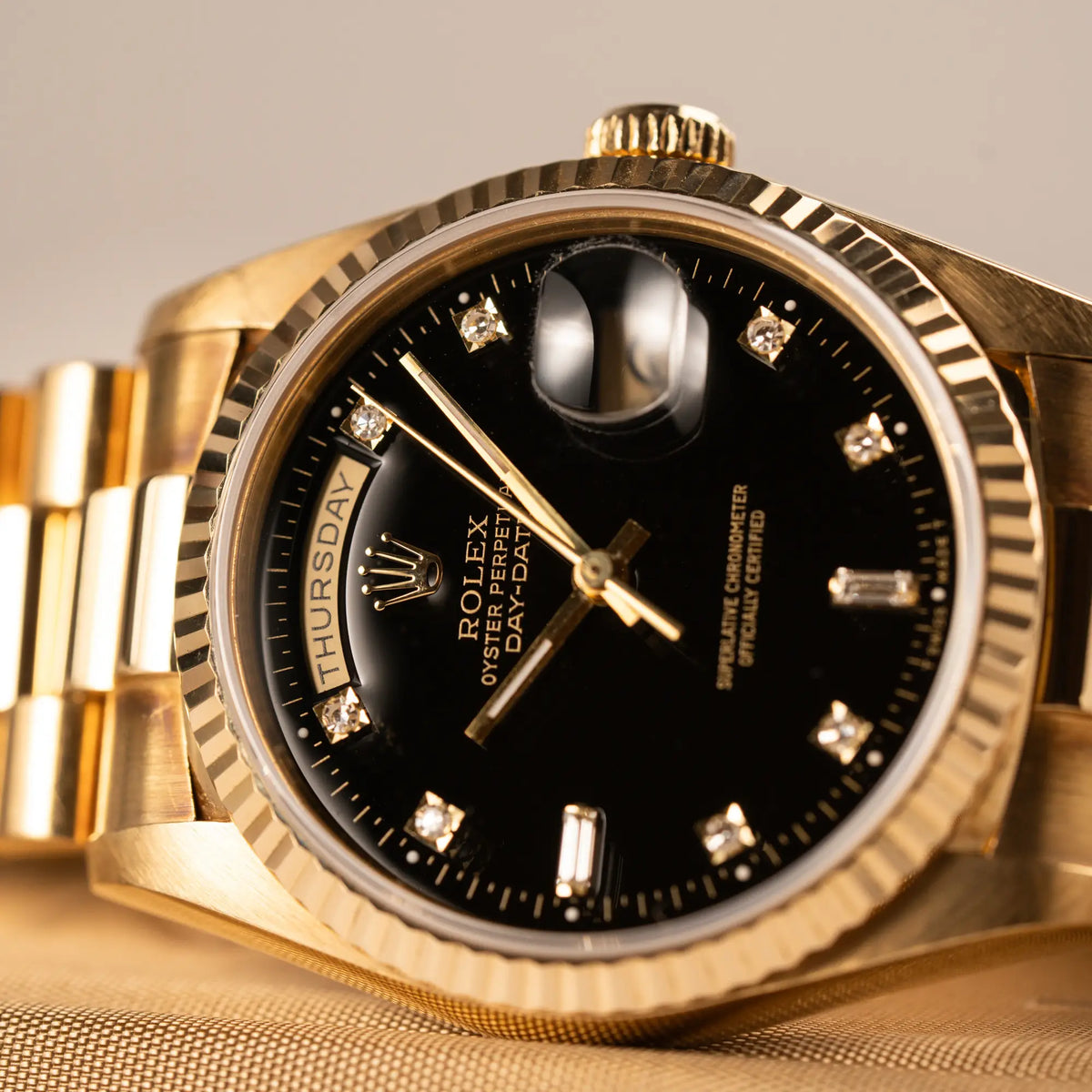 Detailaufnahme der Rolex Day-Date 36 in Gelbgold mit der Referenznummer 18238 mit englisches Tagesanzeige, mit schwarzem Lack-Zifferblatt und Diamant-Indizes 