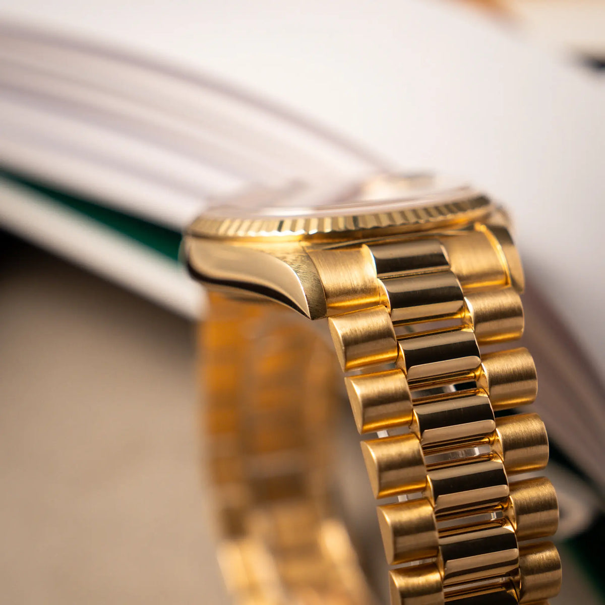 Produktfotografie der gelbgoldenen Rolex Day-Date 36 der Referenz 18238 mit blauem Zifferblatt und englisch-sprachiger Tagesanzeige mit Fokus auf dem President-Armband