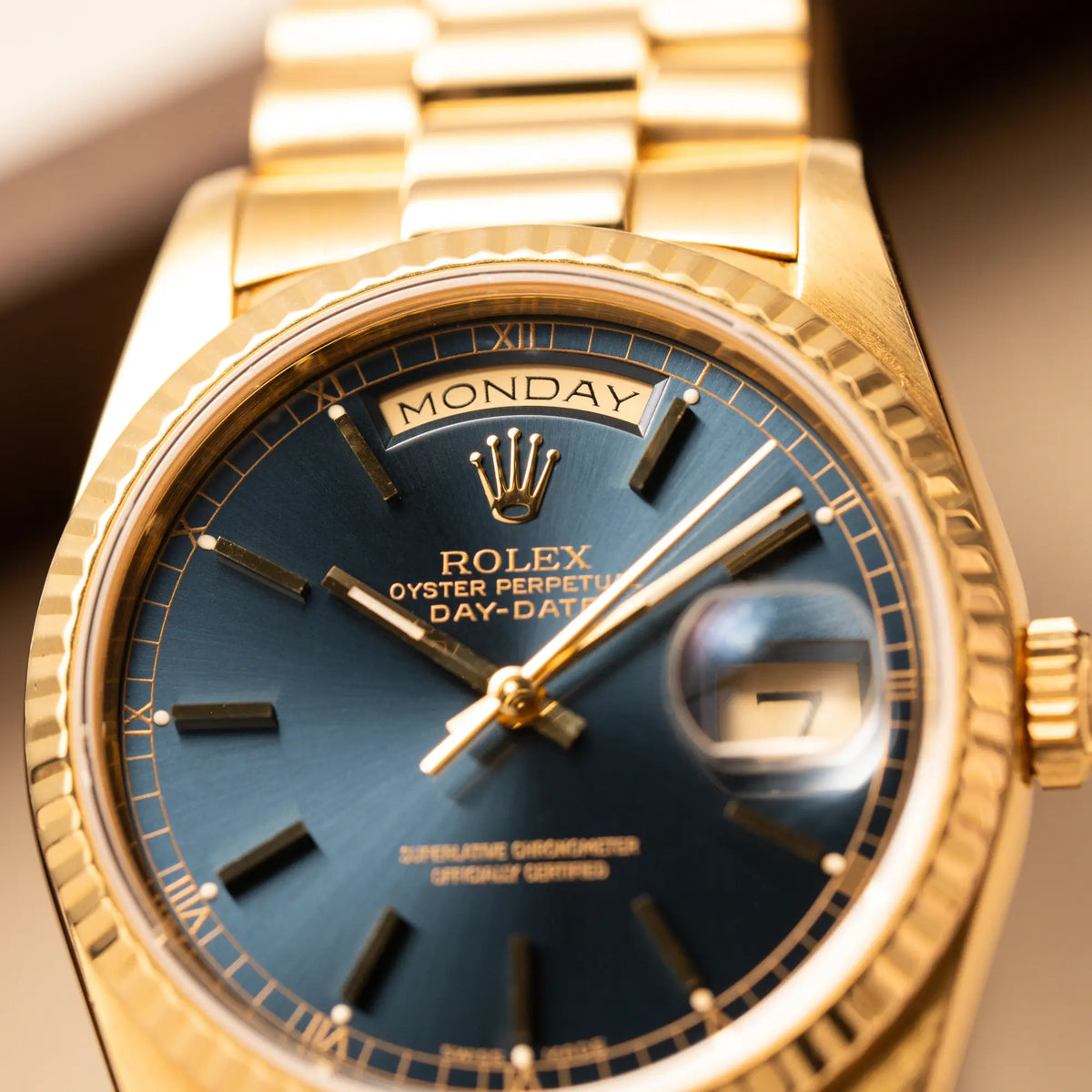 Detailaufnahme des blauen Sonnenschliff-Zifferblatts der gelbgoldenen Rolex Day-Date 36 der Referenz 18238 mit englisch-sprachiger Tagesanzeige