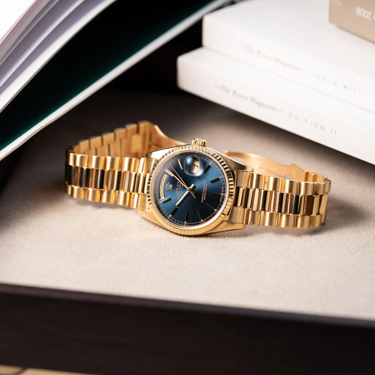 Produktfotografie der gelbgoldenen Rolex Day-Date 36 der Referenz 18238 mit blauem Zifferblatt und englisch-sprachiger Tagesanzeige