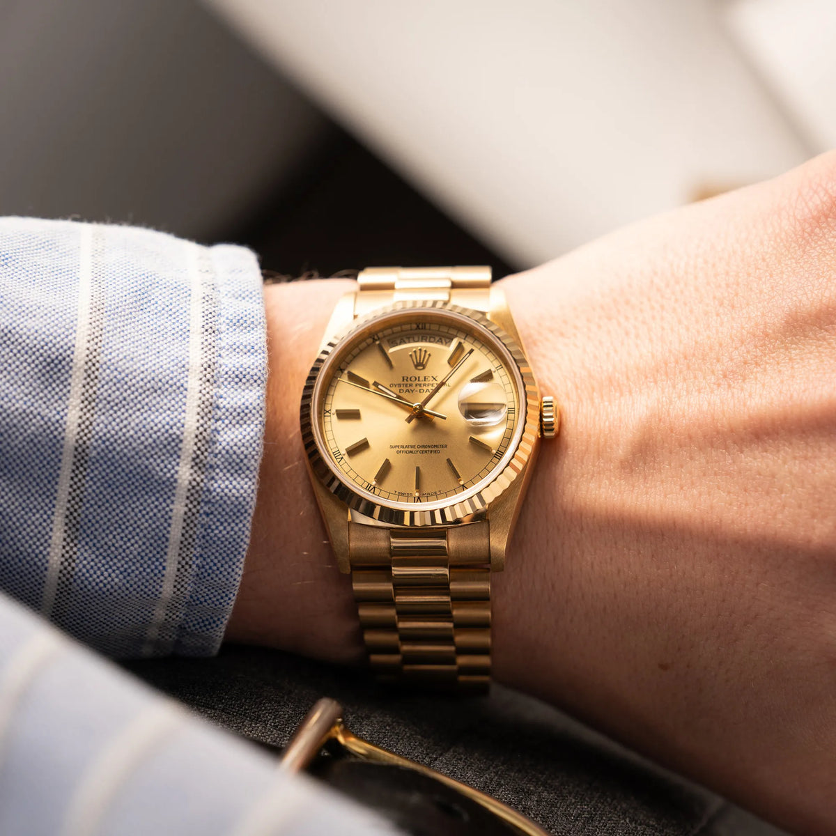 Mann trägt die Rolex Day-Date 36 der Referenz 18238 in Gelbgold mit champagnerfarbenem Stick-Dial an seinem Handgelenk