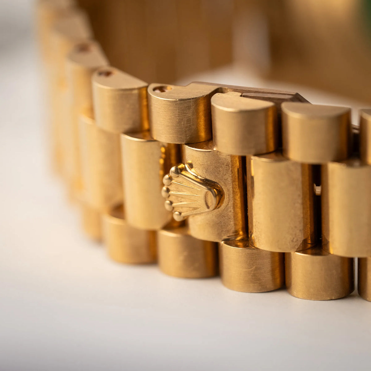 Detailaufnahme der Rolex-Krone auf der Schliesse des President-Armbands der Rolex Day-Date 36 der Referenz 18238 in Gelbgold mit champagnerfarbenem Stick-Dial