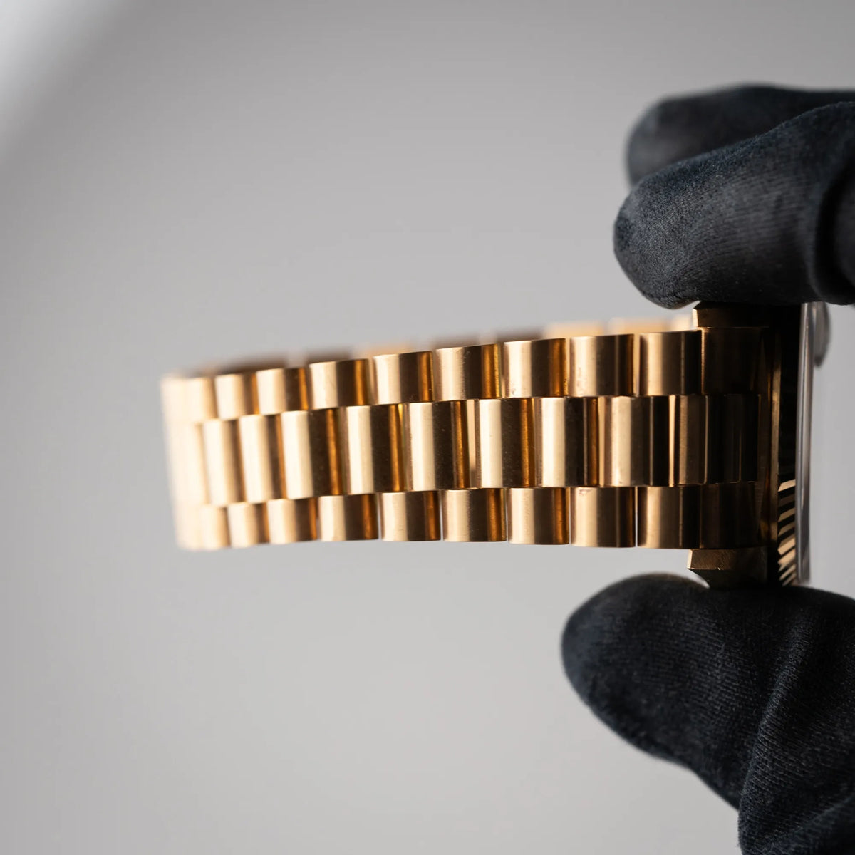 Mann hält die Rolex Day-Date 36 der Referenz 18238 in Gelbgold mit champagnerfarbenem Stick-Dial in seiner Hand und präsentiert den nahezu nicht vorhandenen Stretch des President-Armbands