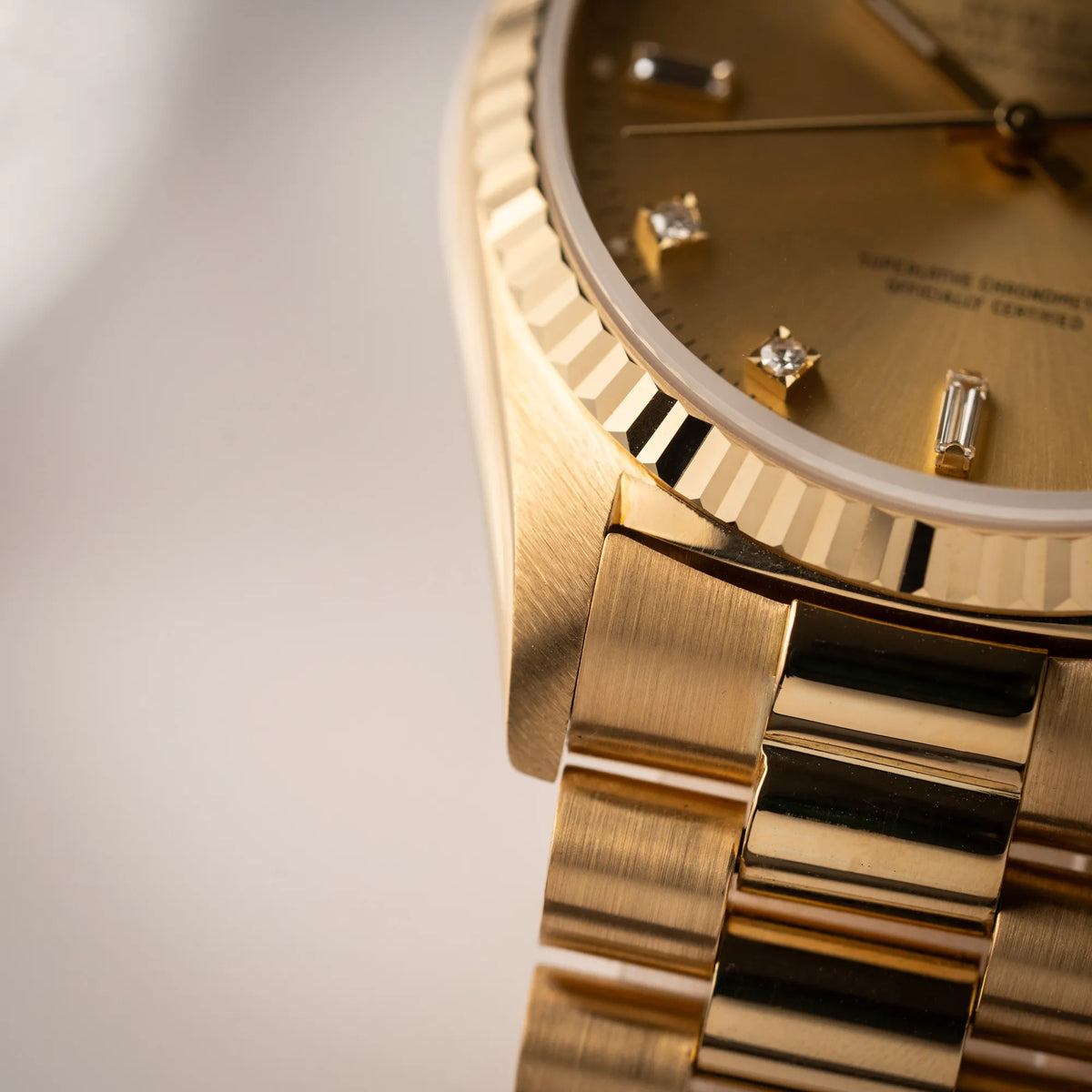 Detailaufnahme des linken unteren Bandanstoßes der Rolex Day-Date 36 in Gelbgold der Referenz 18238 aus 1991 mit Champagner-Diamant-Zifferblatt und englischsprachiger Tagesanzeige