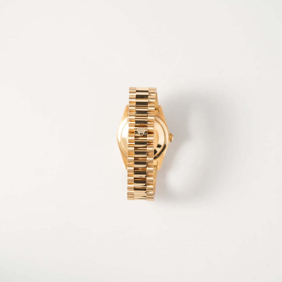 Blick auf das President-Armband mit scharfkantiger Rolex-Krone auf der Schliesse von der Rolex Day-Date 36 in Gelbgold der Referenz 18238 aus 1991 mit Champagner-Diamant-Zifferblatt und englischsprachiger Tagesanzeige