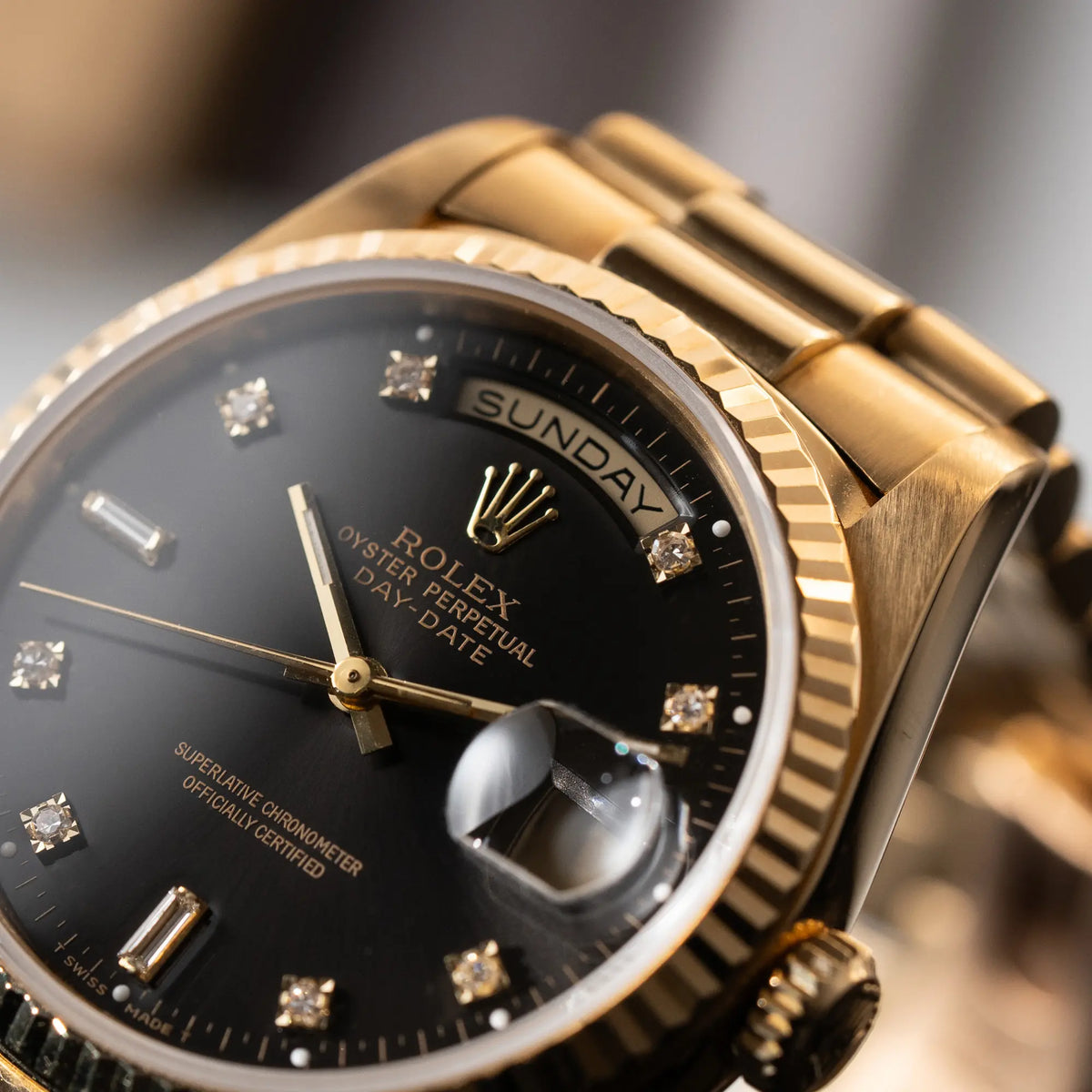 Detailaufnahme der Rolex Day-Date 36 der Referenz 18238 im klassischen Gelbgold mit einem schwarzen Diamond Dial und englischsprachiger Wochentagsanzeige