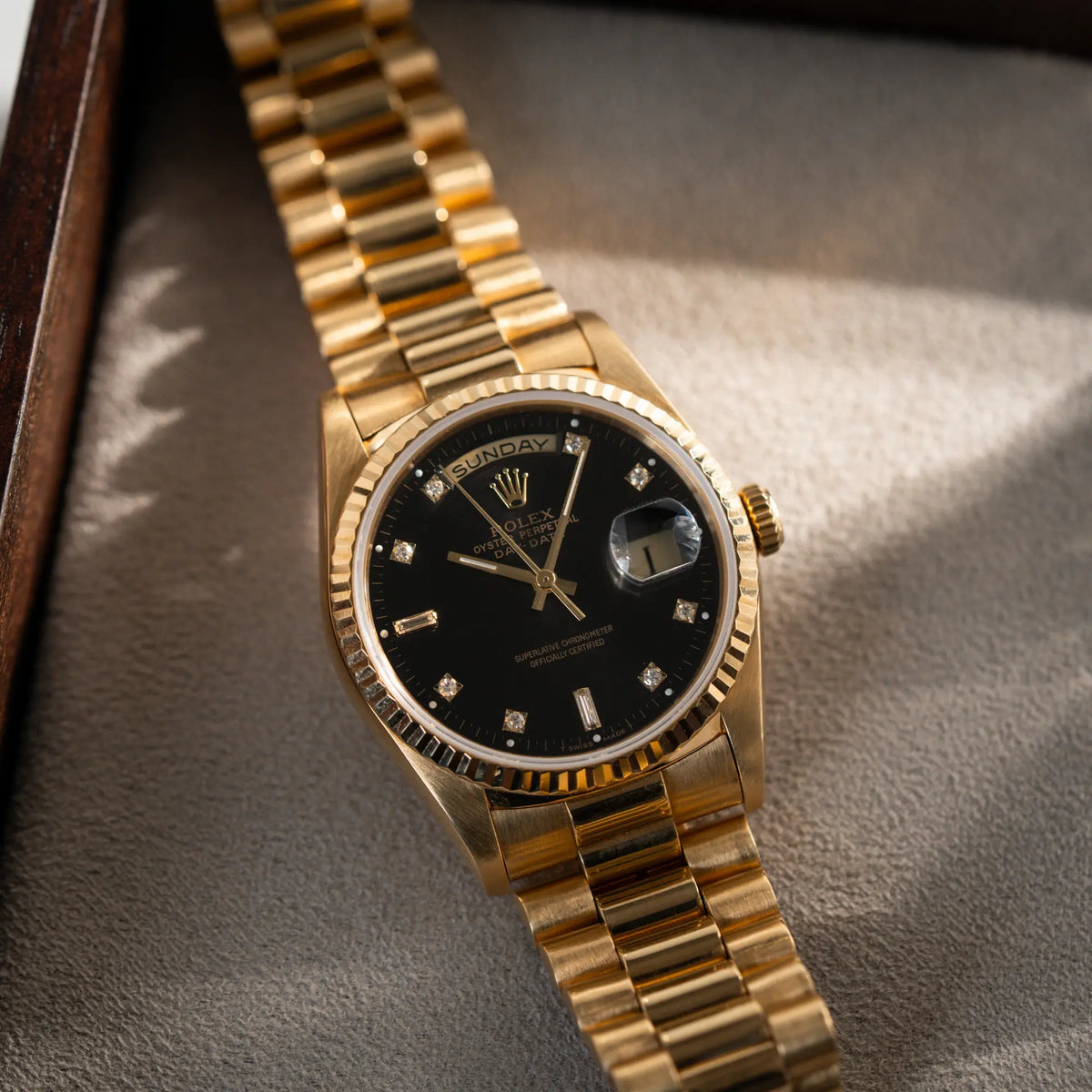 Produktfotografie der Rolex Day-Date 36 der Referenz 18238 im klassischen Gelbgold mit einem schwarzen Diamond Dial und englischsprachiger Wochentagsanzeige