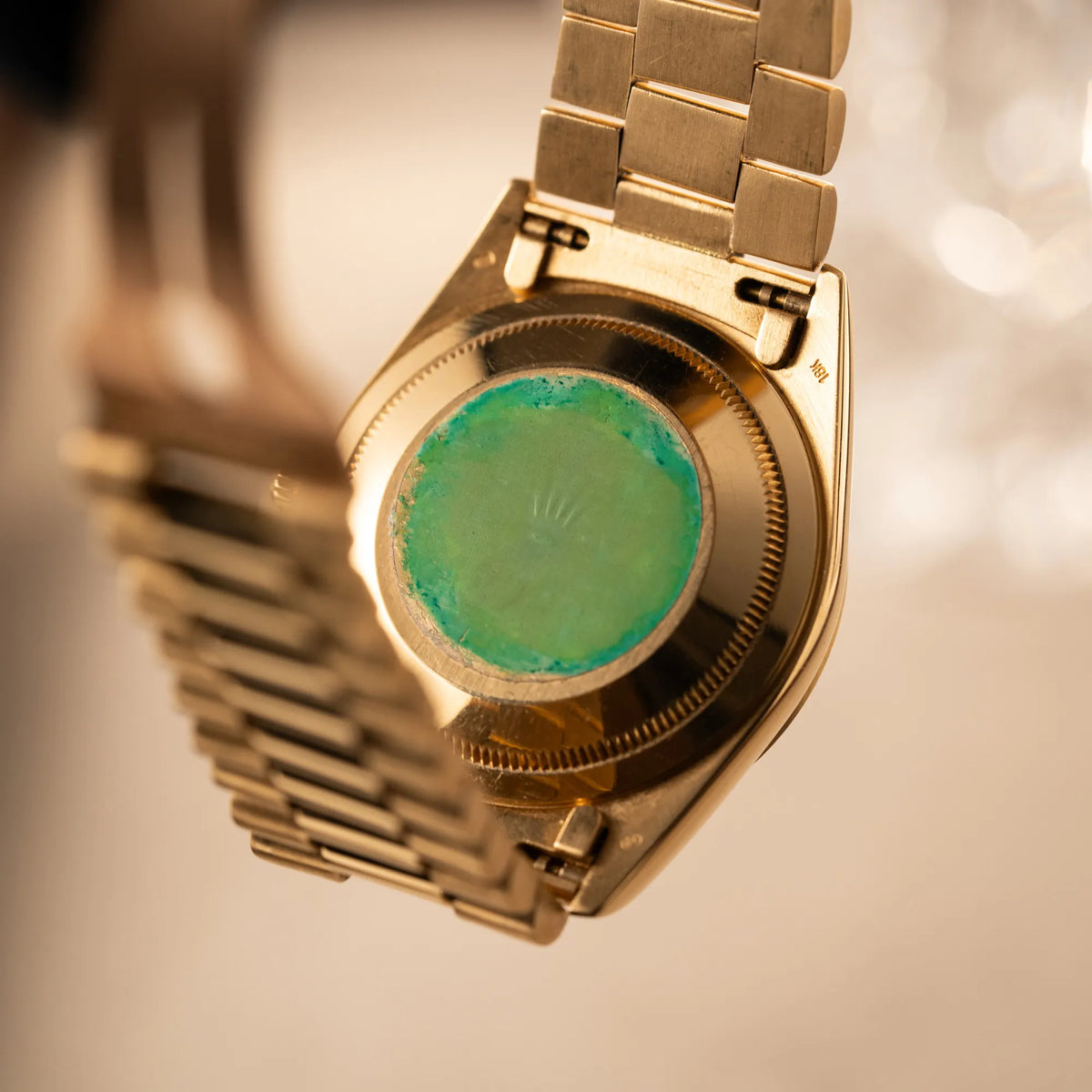 Produktfotografie zeigt den Gehäuseboden der Rolex Day-Date 36 der Referenz 18238 im klassischen Gelbgold mit einem schwarzen Diamond Dial und englischsprachiger Wochentagsanzeige