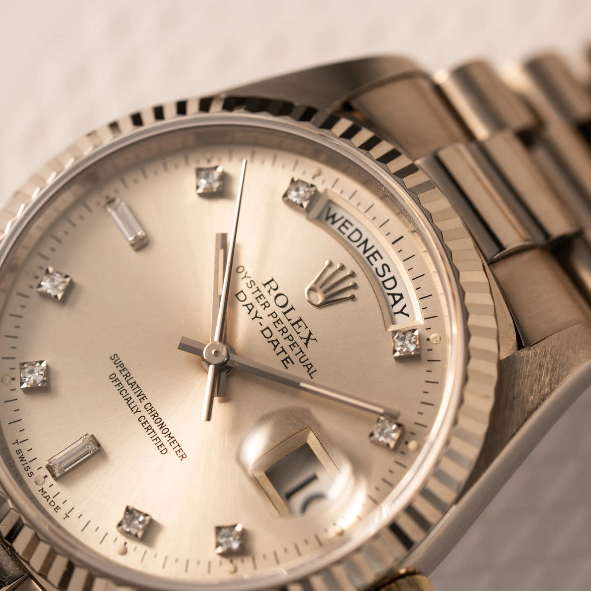Detailaufnahme der englischsprachigen Tagesanzeige auf 12Uhr von der Rolex Day-Date der Referenz 18239 in 36 mm aus 18 karätigem Weißgold mit silbernem Diamant-Zifferblatt